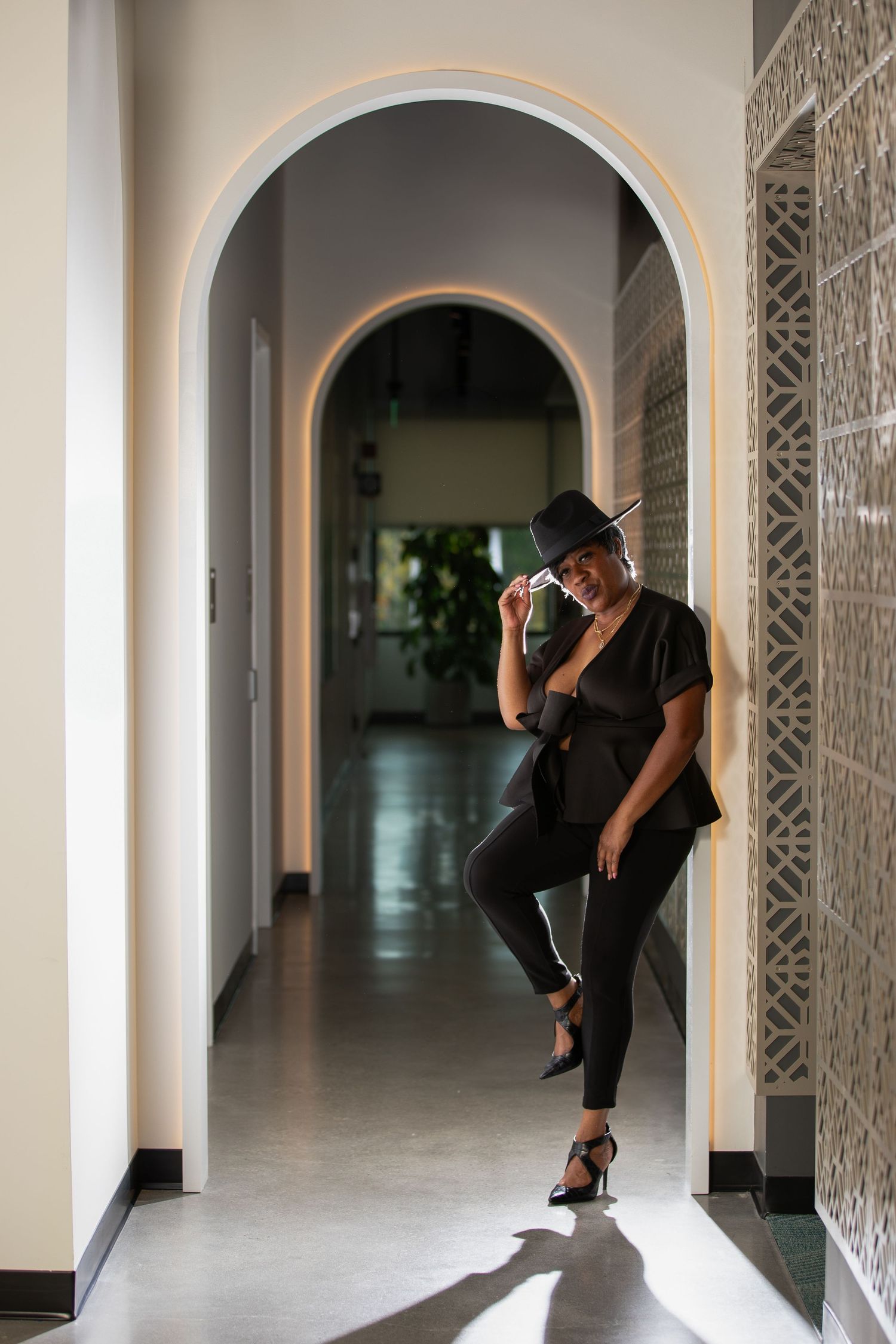 Artistic fashion poses captured in a corridor with ornate architectural details.
