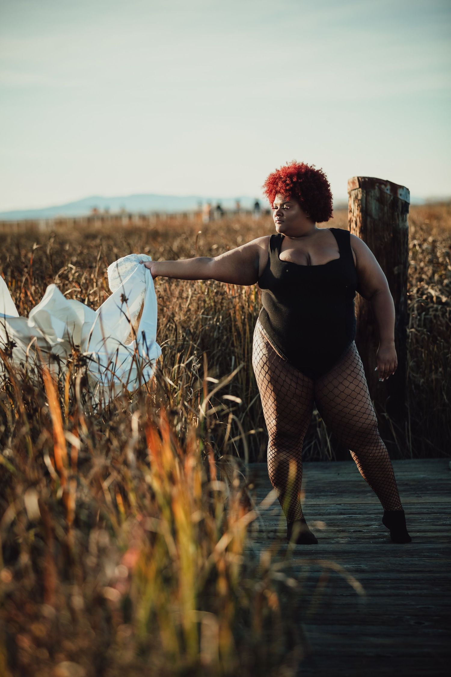 Dynamic fashion photography sequence on wooden walkway surrounded by tall grass.