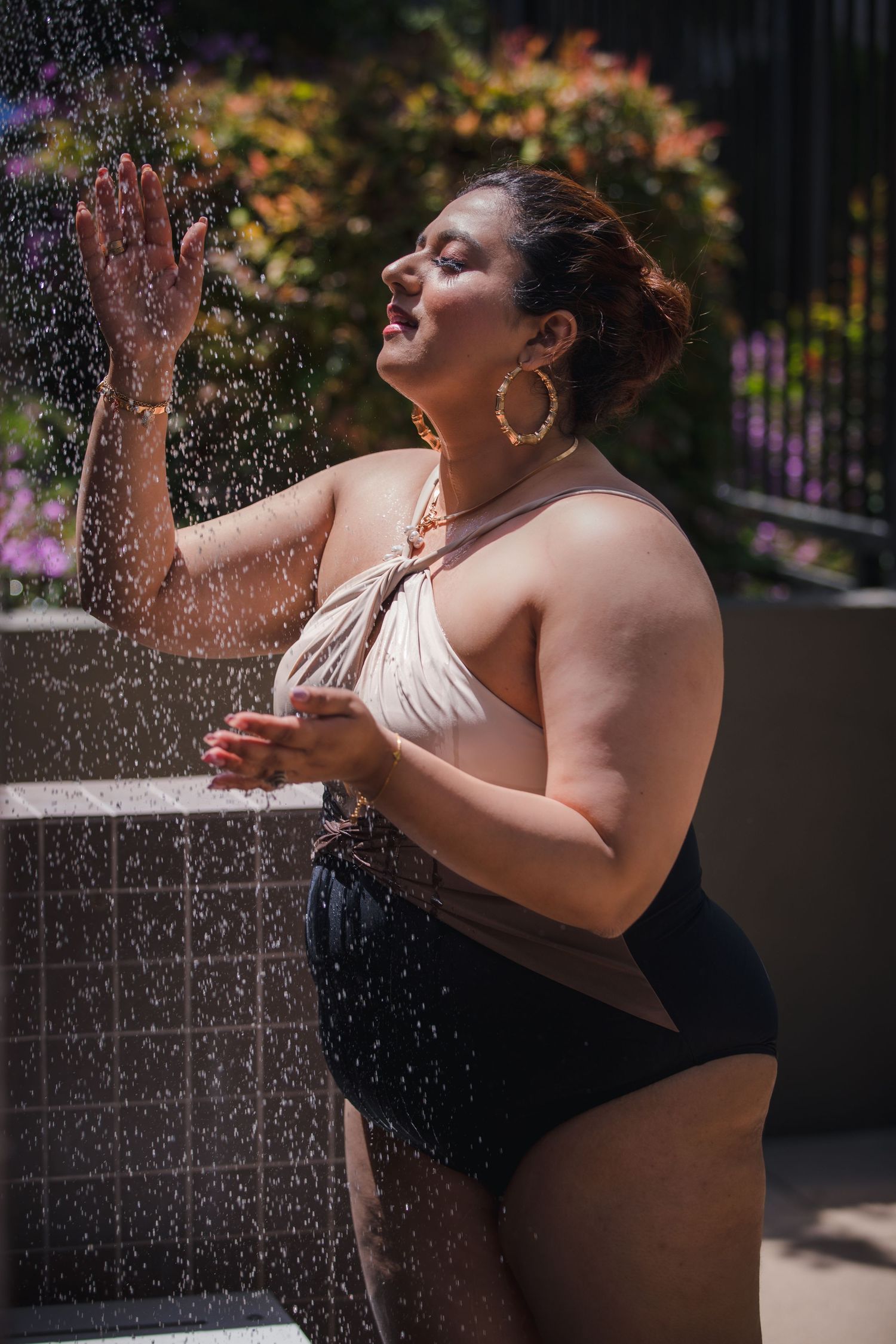 Artistic summer portrait with water droplets and swimwear in natural outdoor lighting.
