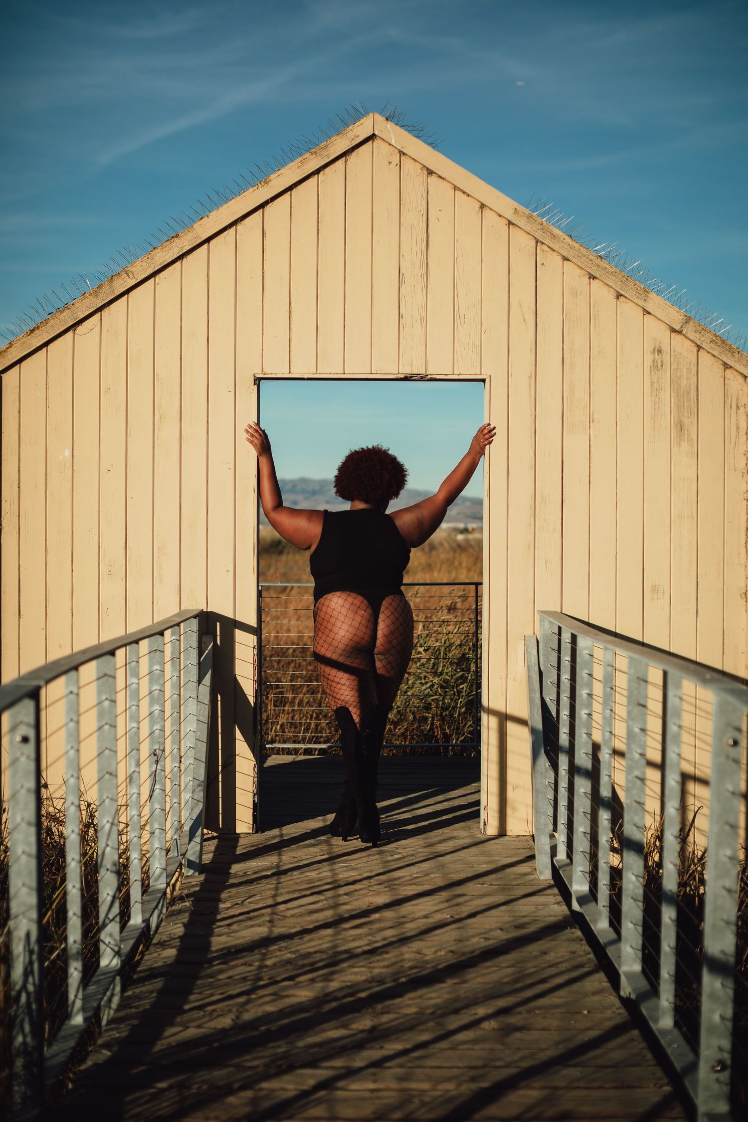 Dynamic movement captured in silhouette against a wooden building during sunset.