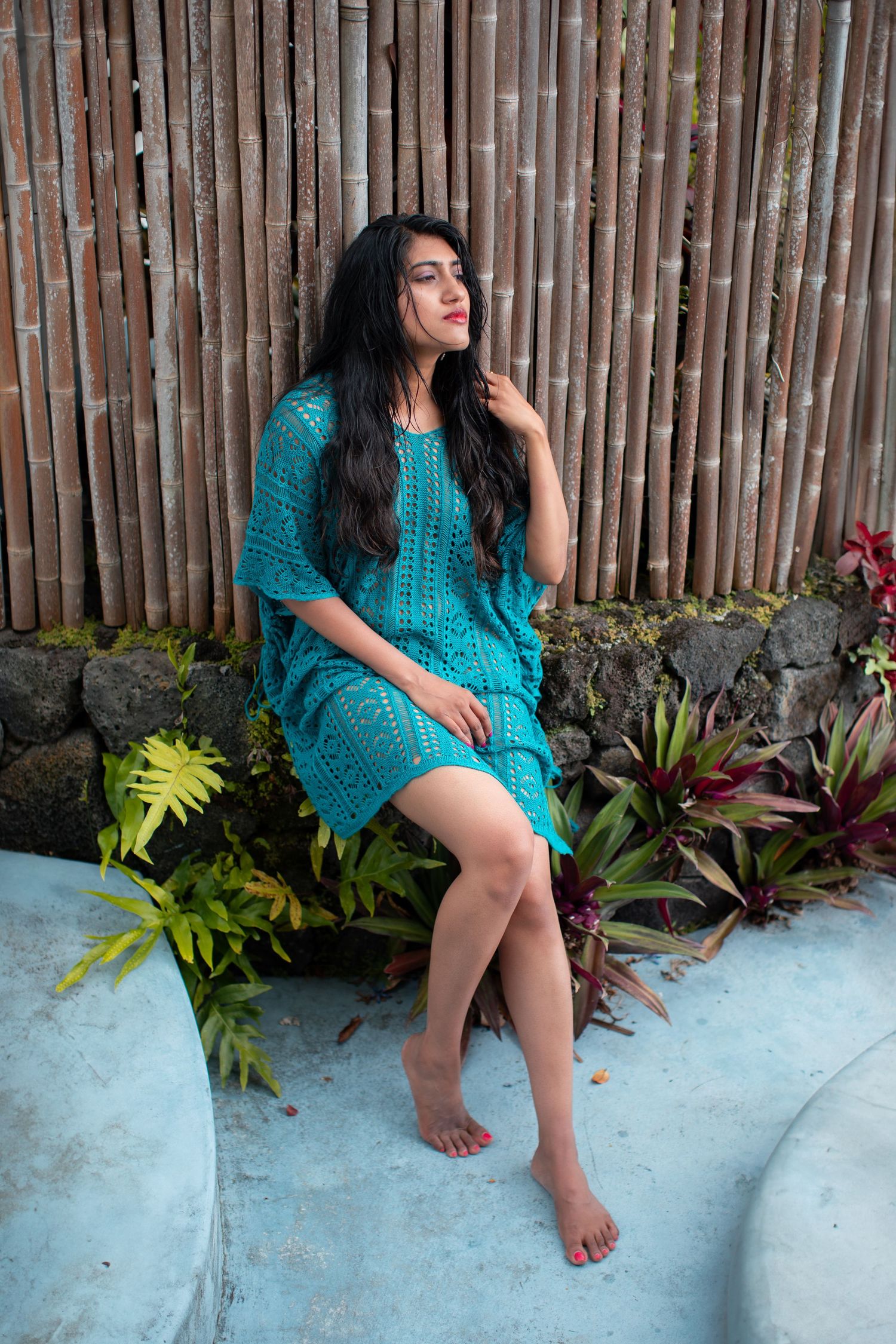 Casual outdoor portrait with bamboo fence background and turquoise dress.