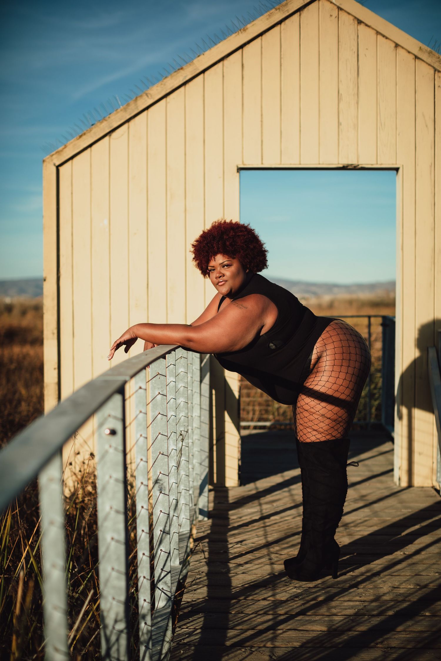 Dance-inspired poses captured in golden light on a wooden deck against a light colored building.