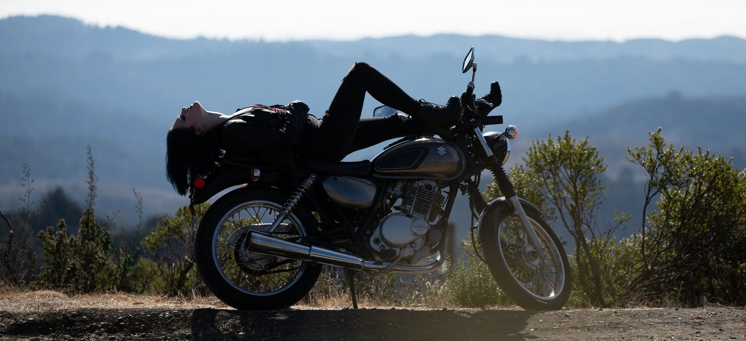 Vintage motorcycle overlooking mountainous landscape in natural daylight.