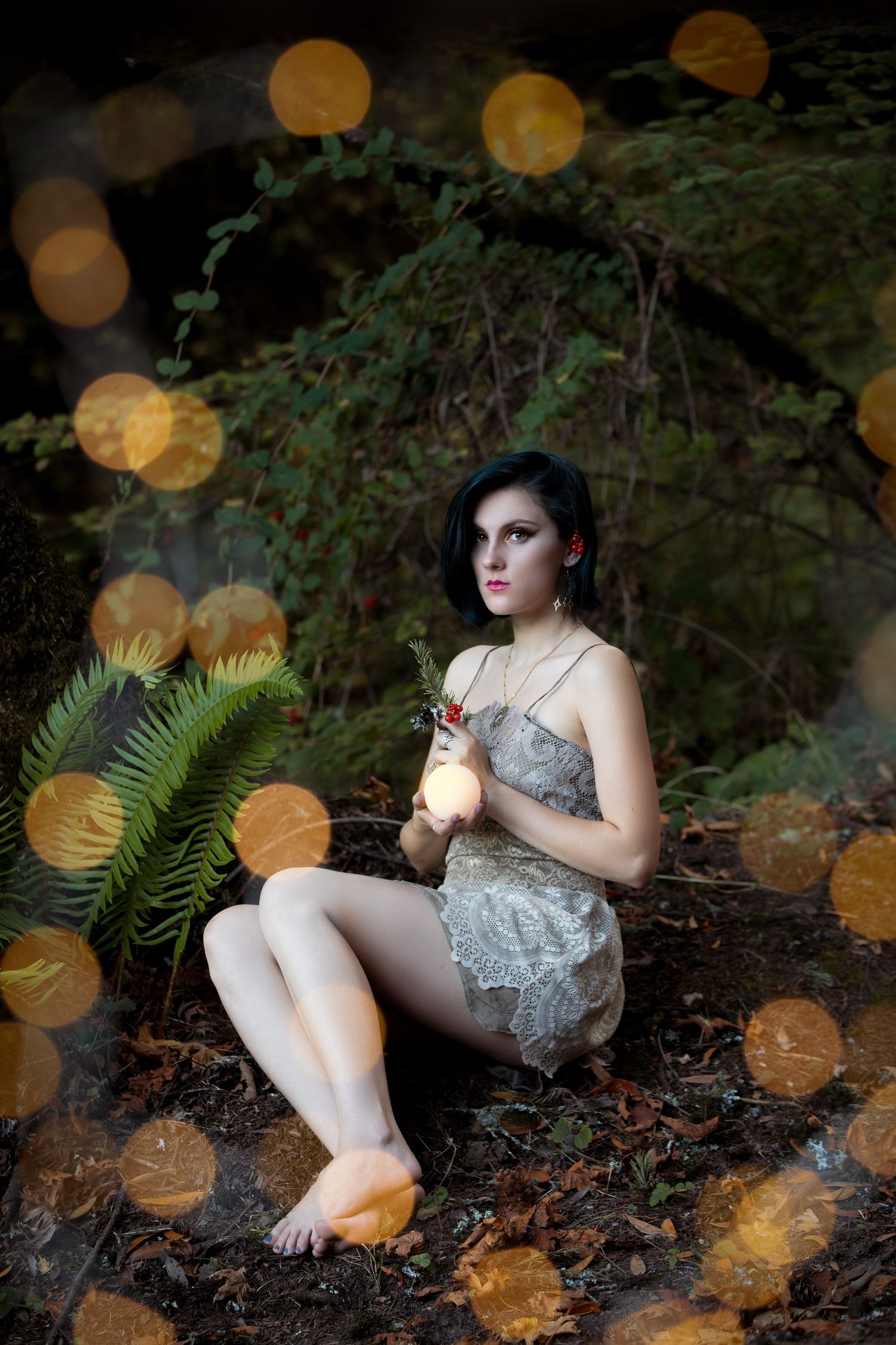 Artistic portrait in a forest setting with golden bokeh lighting effects.