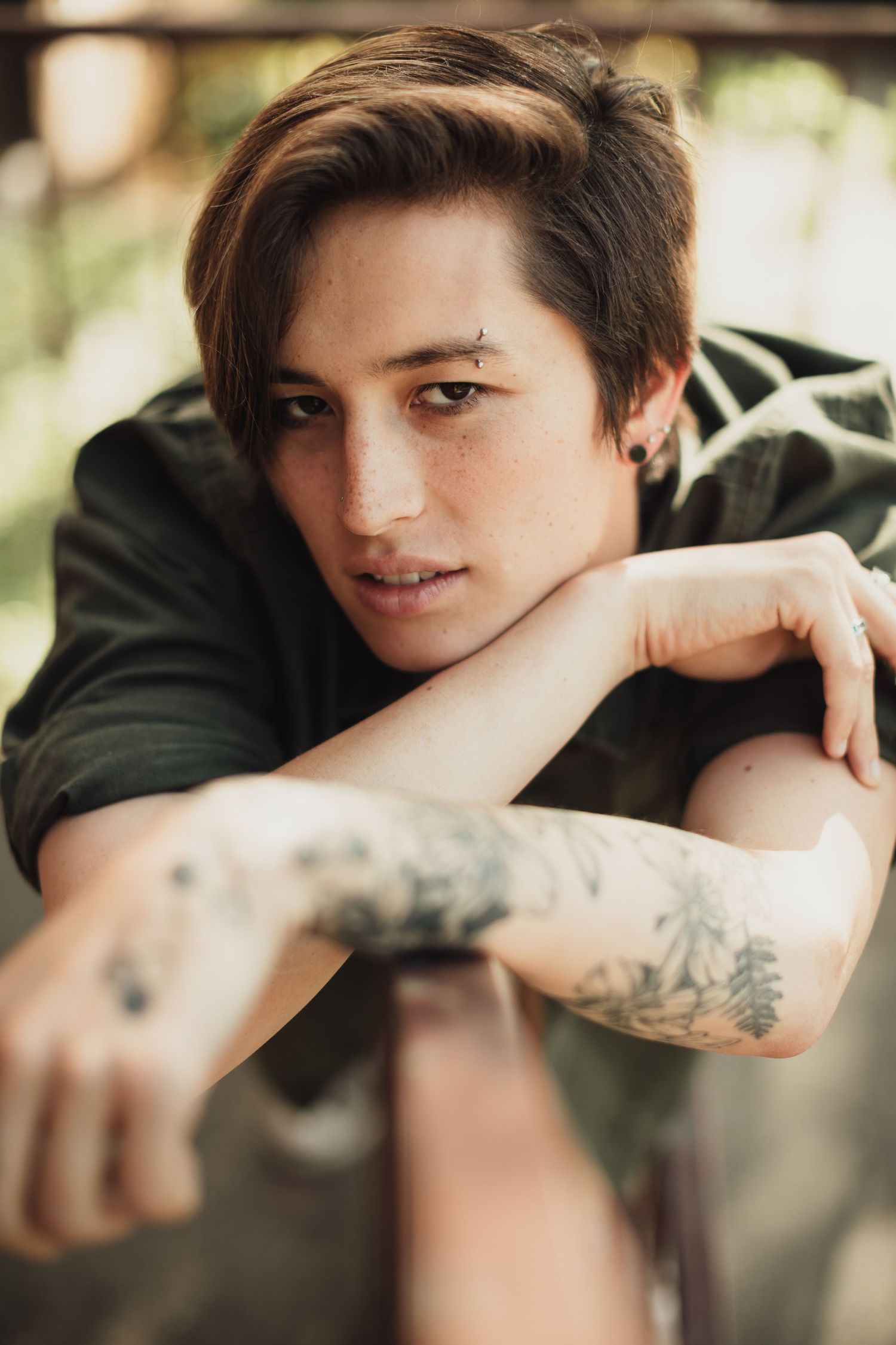 Close-up shots highlighting tattoo art and casual style against outdoor setting.
