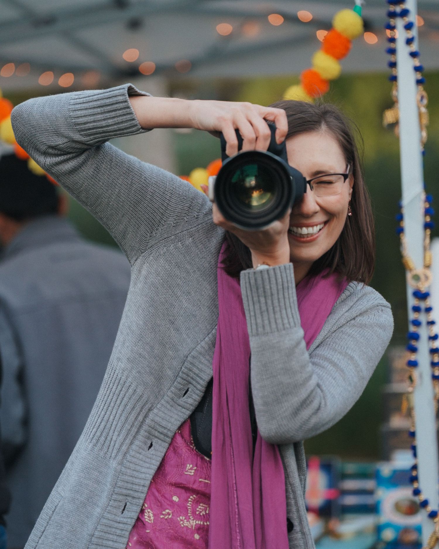 A photographer takes pictures at an outdoor event with festive decorations.