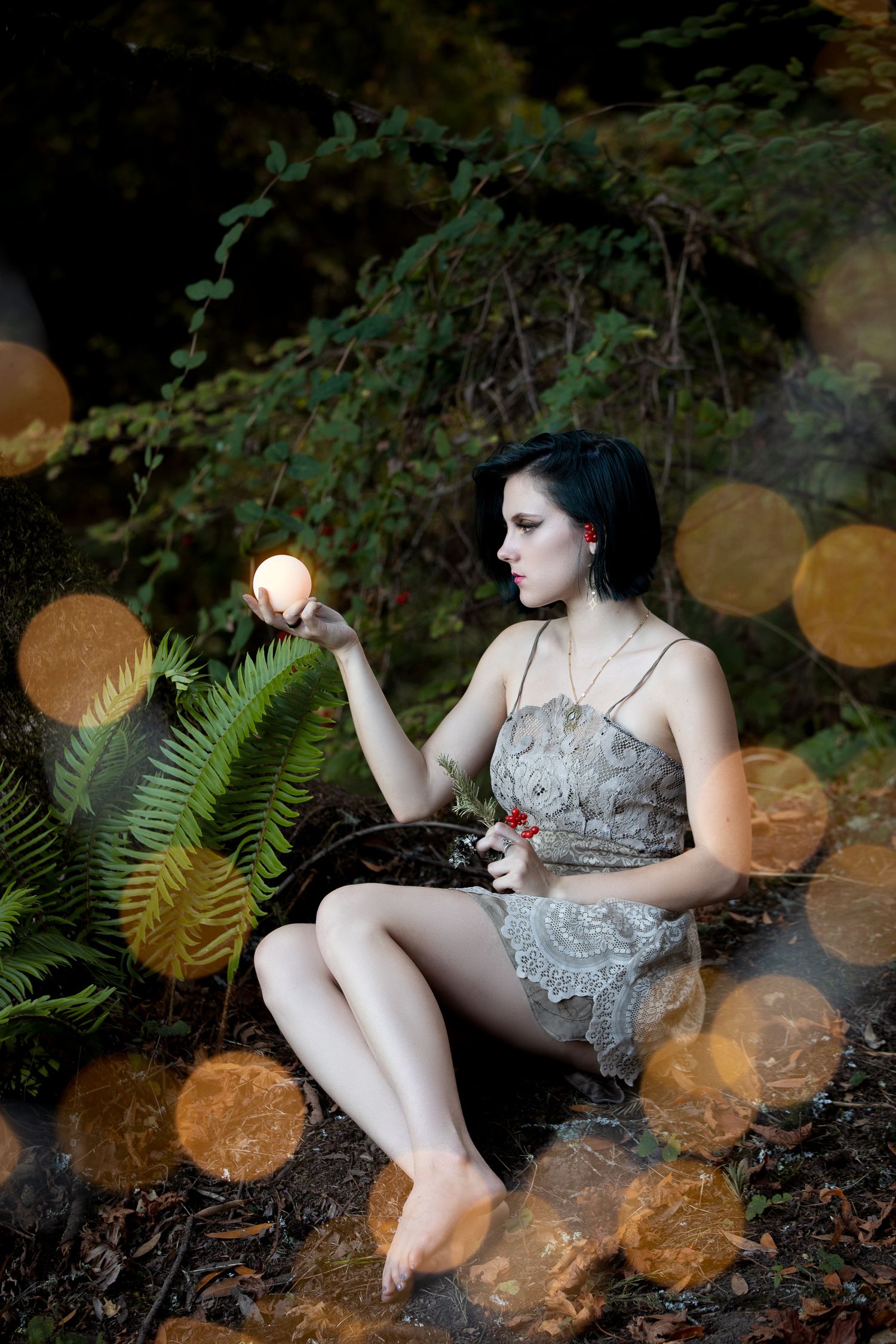 Moody forest portrait with golden bokeh effects and ferns.