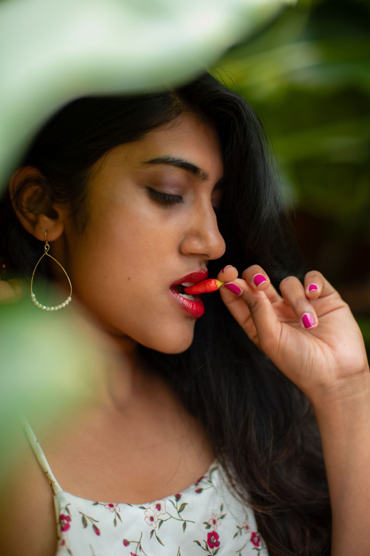 Close-up portrait with bright red lipstick and delicate floral details.