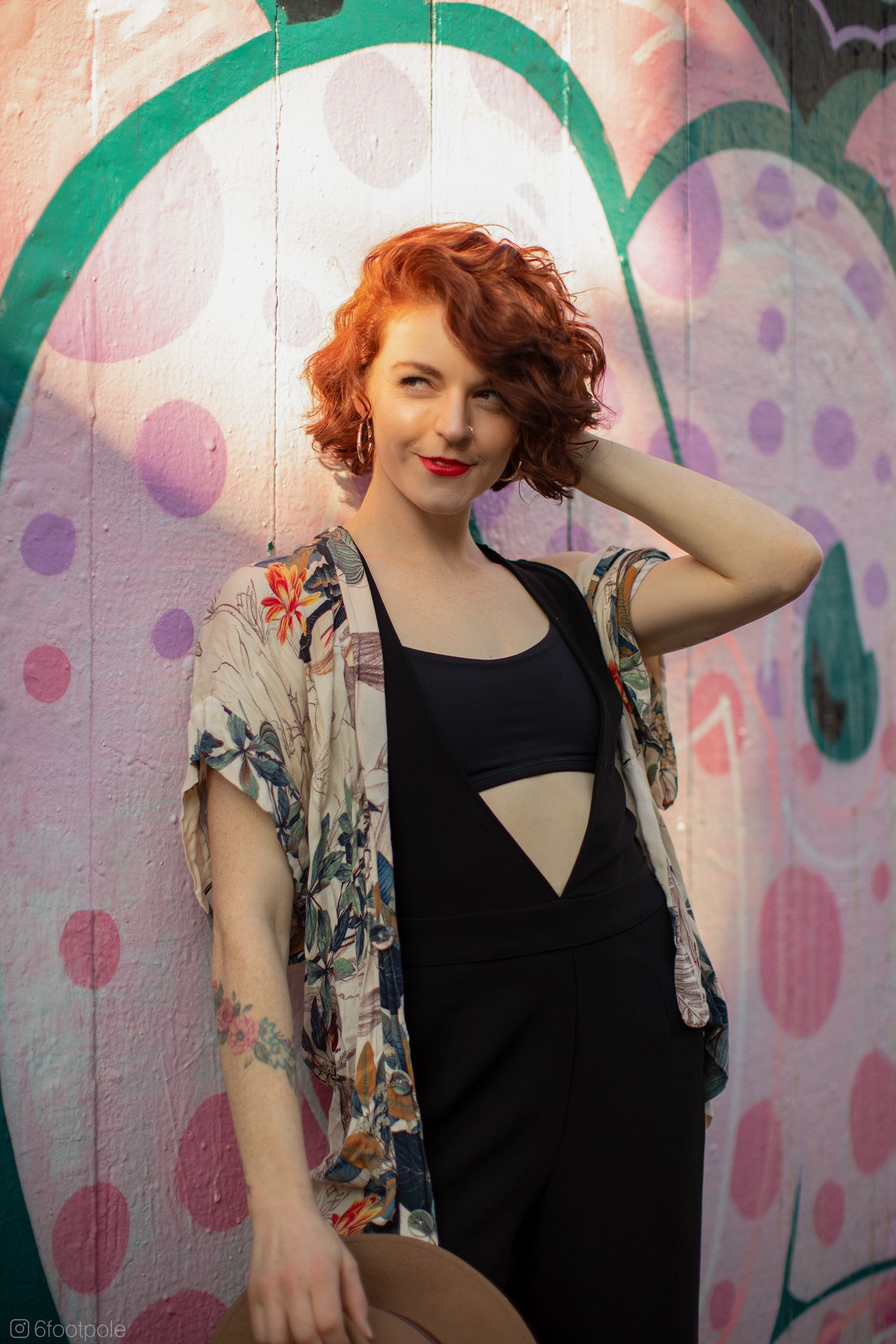 Fashion portrait against colorful graffiti wall featuring floral print kimono and black tank top.