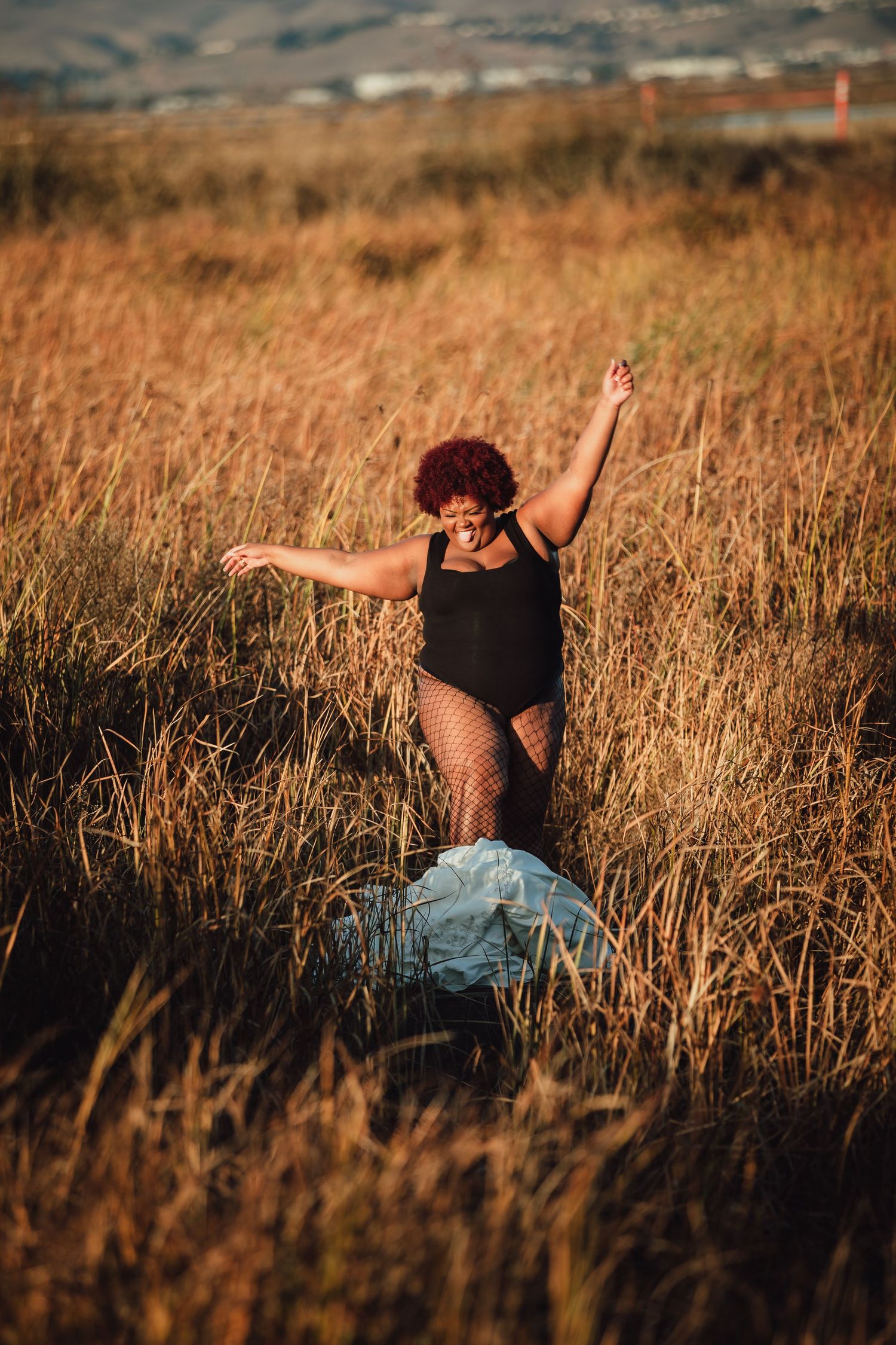 A silhouette dances in a field of tall grass during golden hour.
