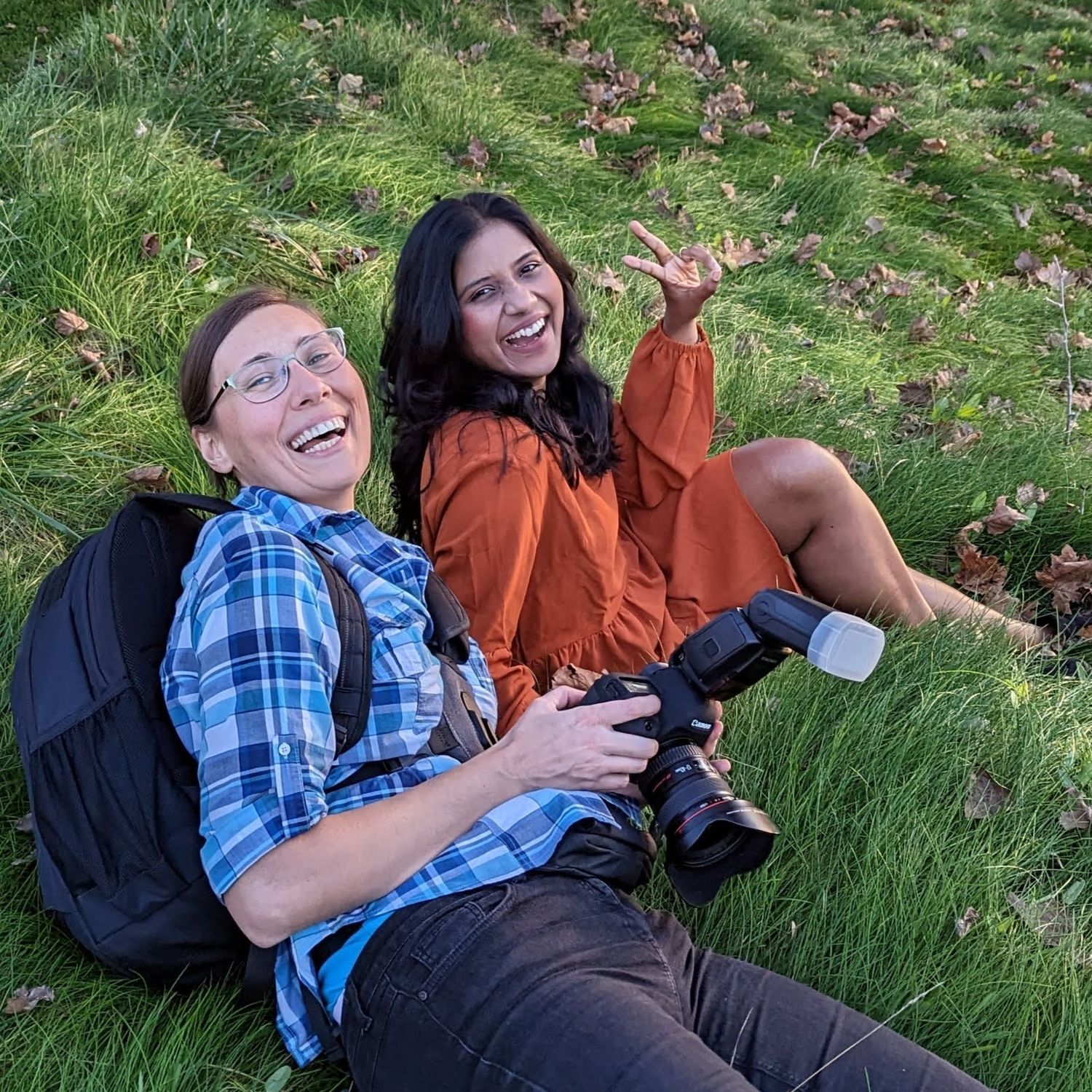 Candid photography session on grass showing Gosia and her client laughing and having fun.