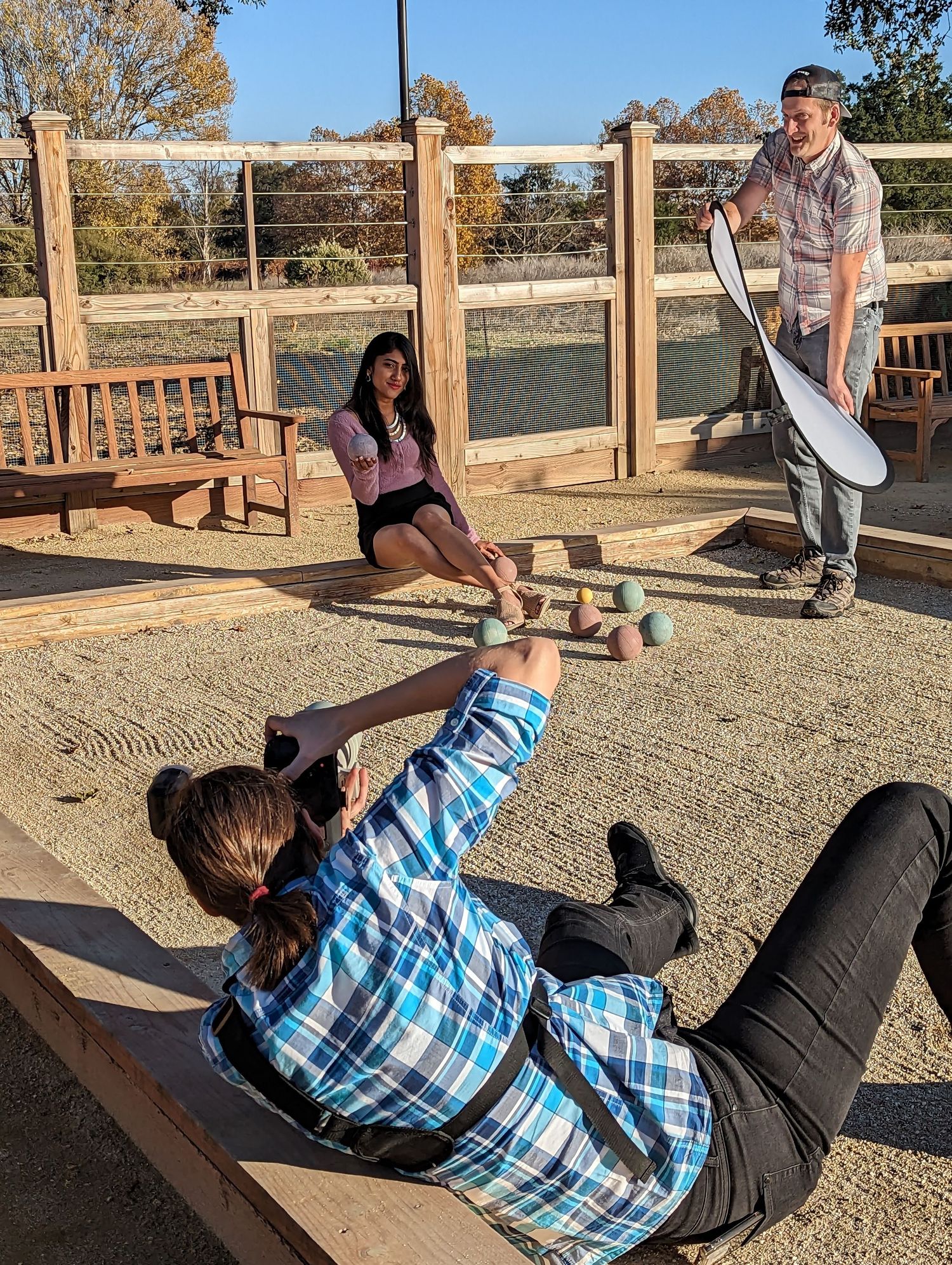 A sequence of photos showing someone demonstrating how to fall backwards safely on a gravel surface near a wooden fence.