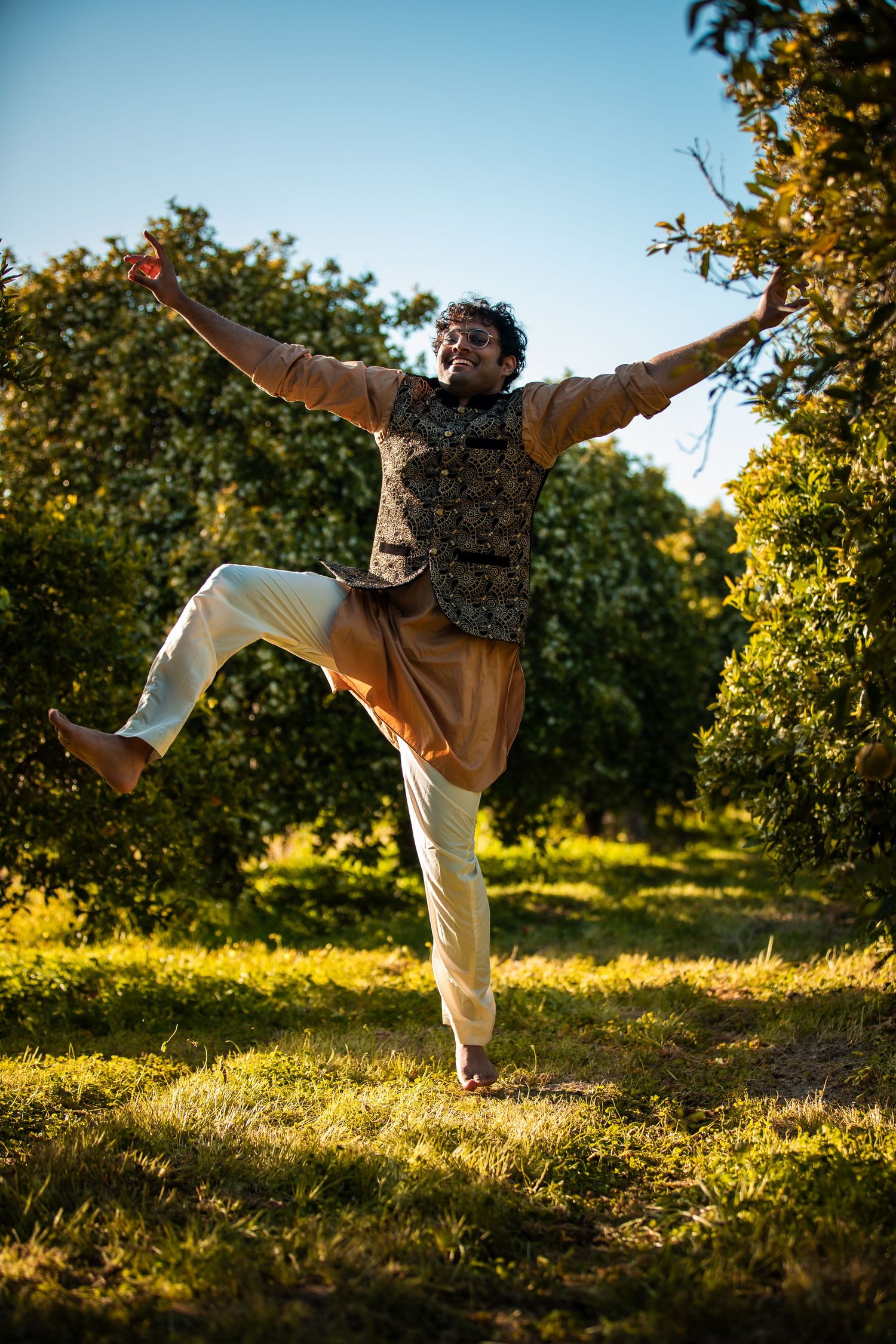 Artistic dance poses performed in garden setting during sunset.