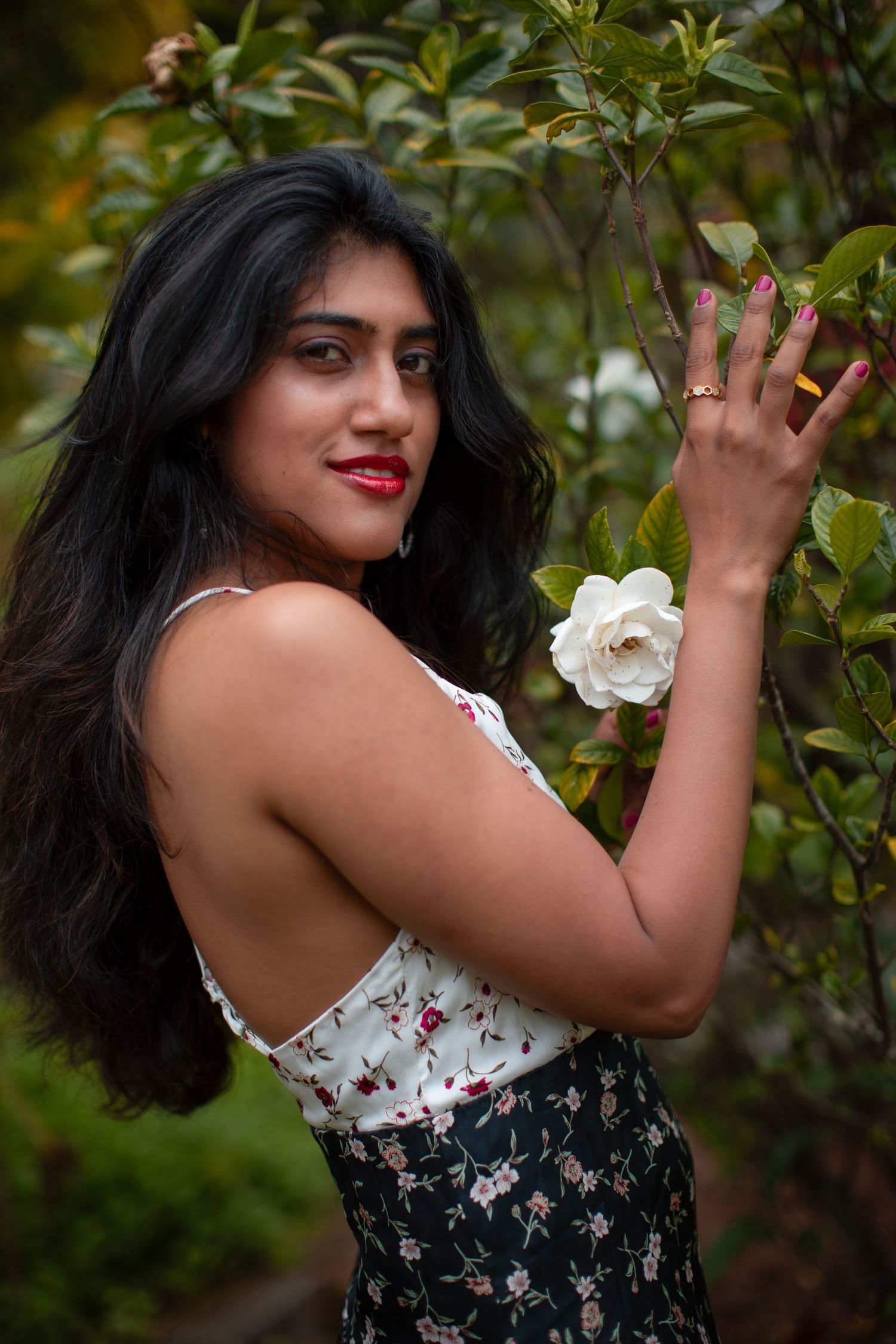 Garden fashion portrait with white roses and floral summer outfit.