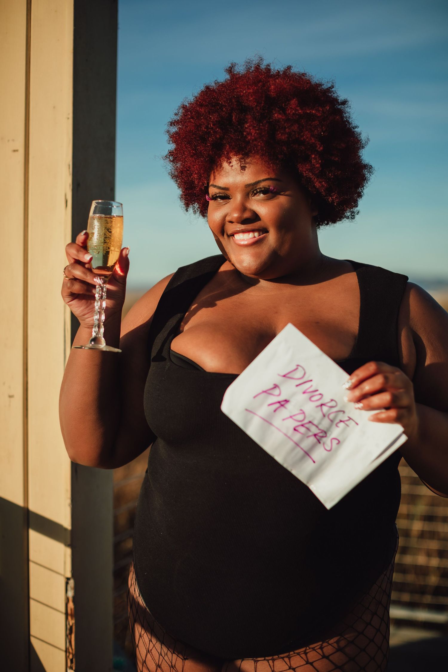 Joyful fashion shoot with champagne and celebration on wooden deck.