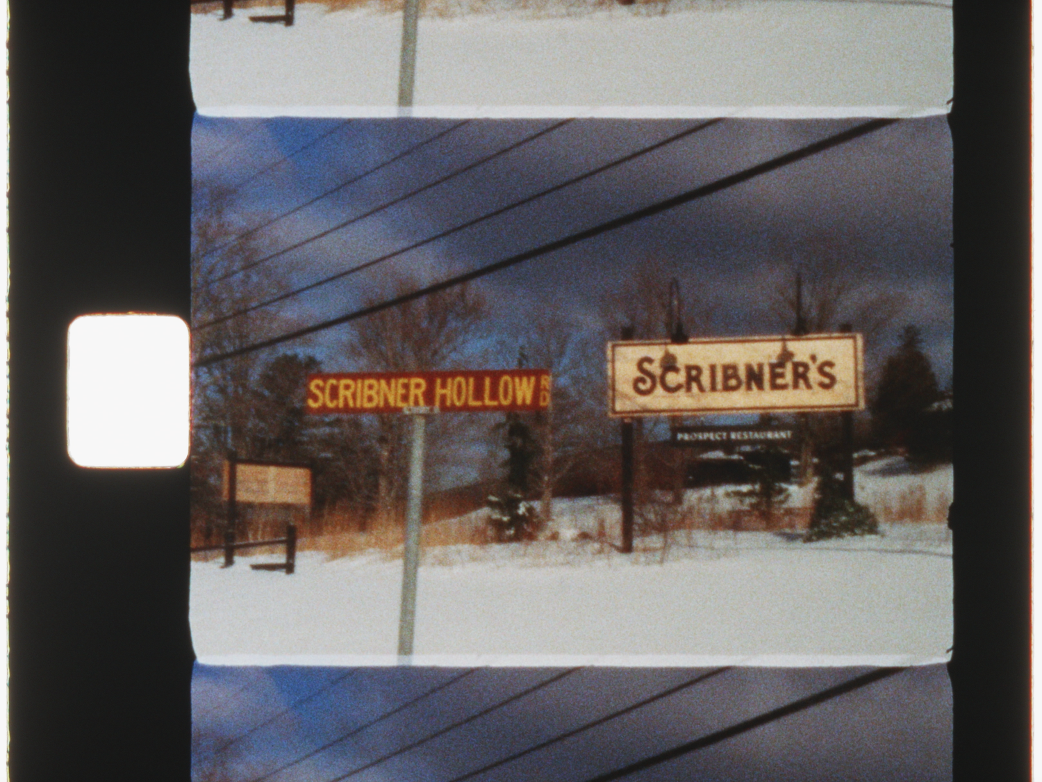 Vintage film strip photo of Scribner's and Scribner Hollow signs in a snowy winter landscape with bare trees.