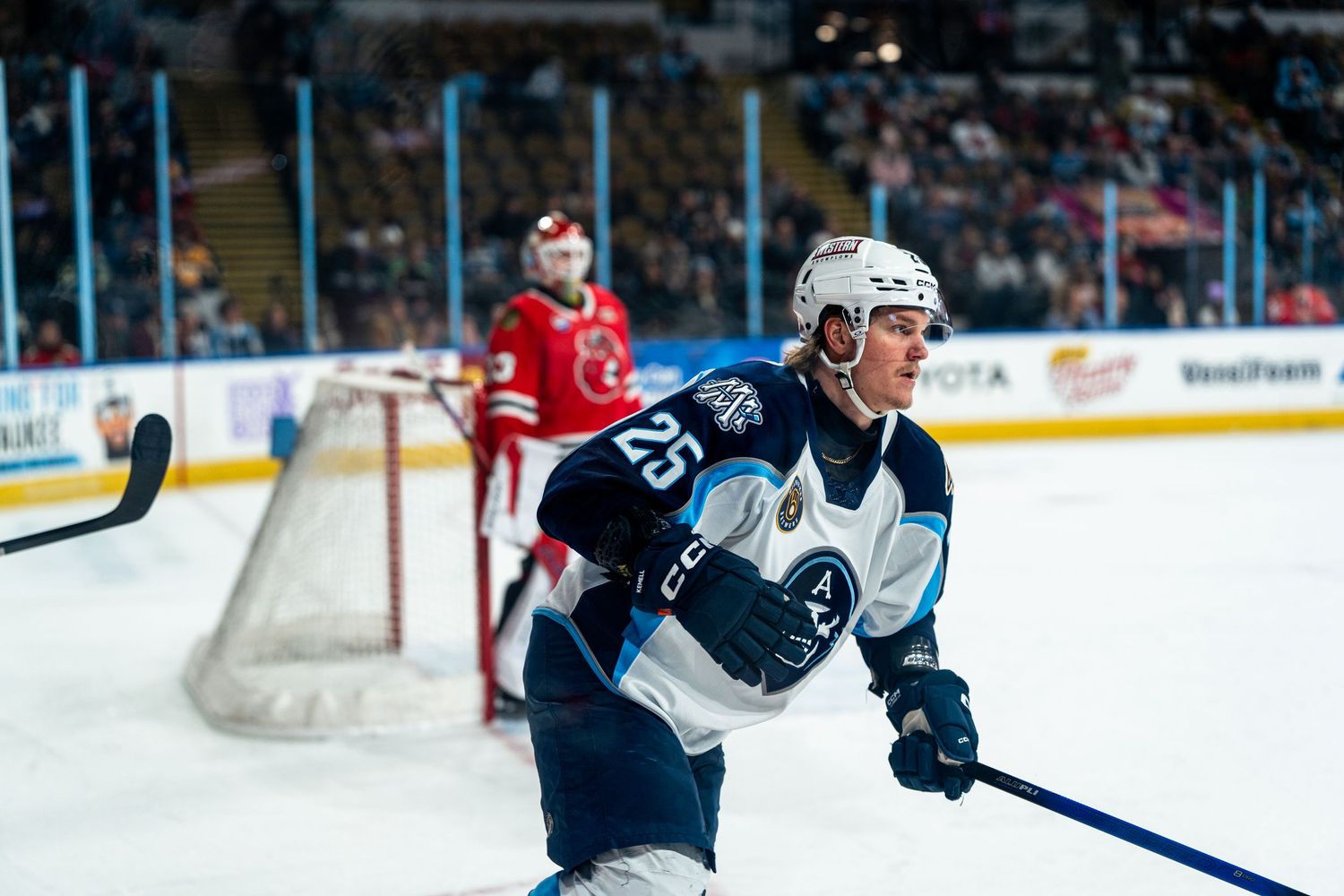 Players chase after a loose puck during a fast-paced professional hockey game.