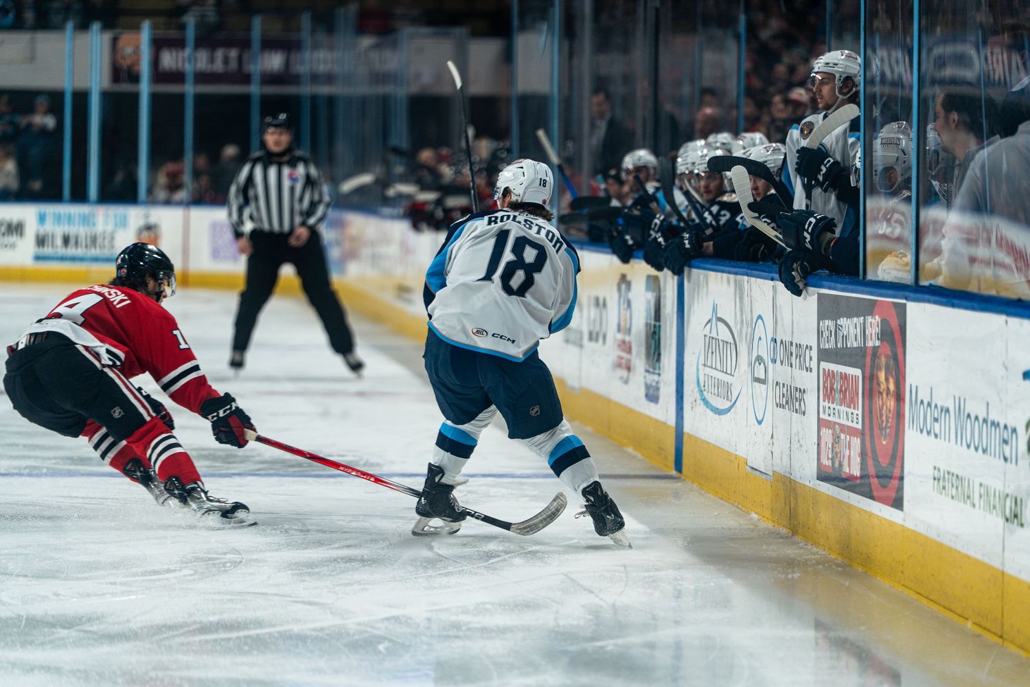 Hockey players engage in a physical battle along the boards during an intense game.