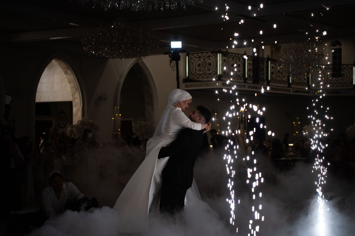 Romantic wedding dance with sparklers and fog effects in an elegant venue.