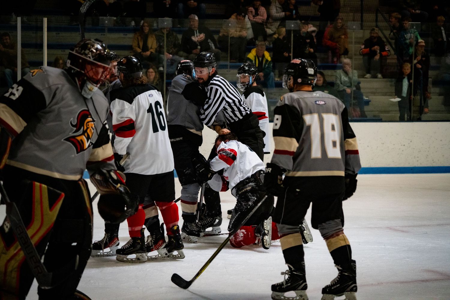 Hockey players from opposing teams gather during a stoppage in play.