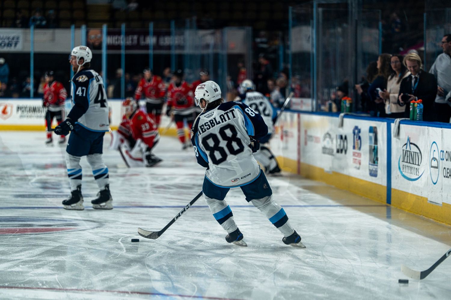 Hockey players compete for the puck during an intense professional ice hockey match.