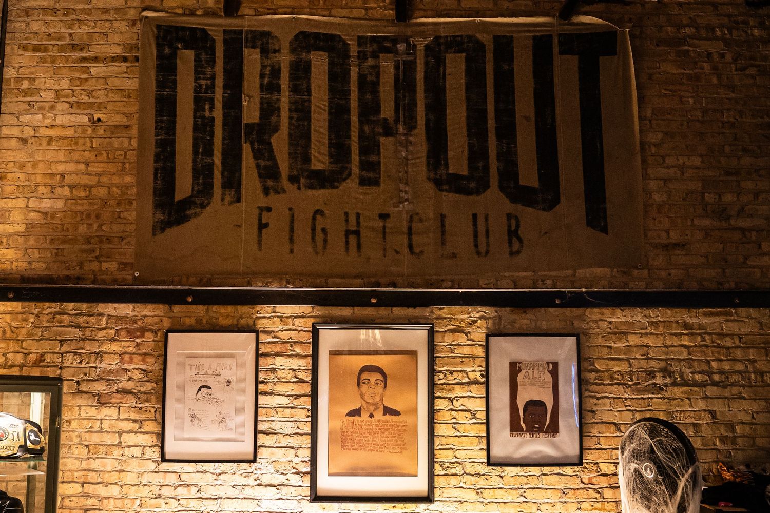 Boxing gym interior with brick walls and vintage fight club signage.