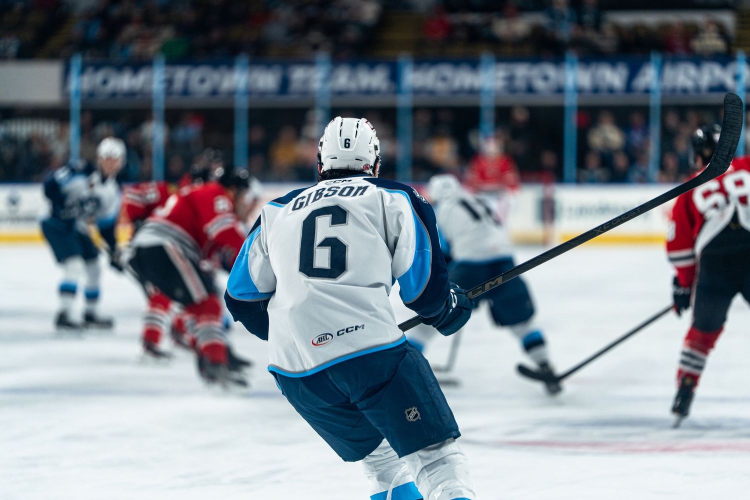 Hockey players compete for the puck during a professional game on ice.