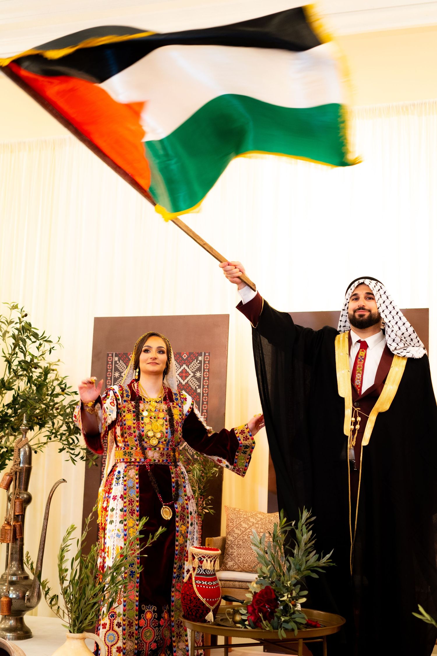 Traditional Palestinian dancers performing with colorful flags and cultural attire during a celebration.