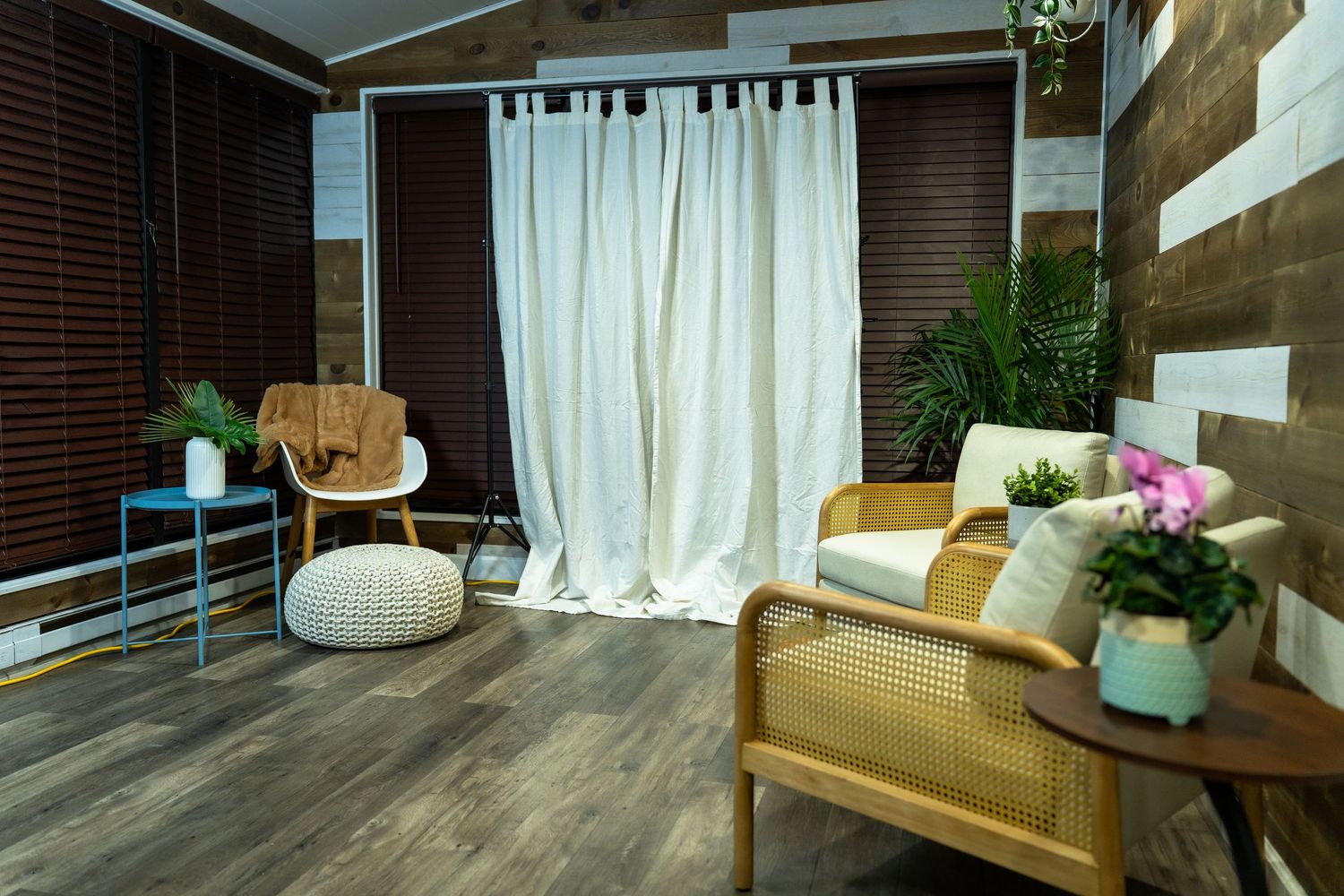Modern apartment interior with wooden floors, white curtains, and natural lighting showcases minimalist design elements.