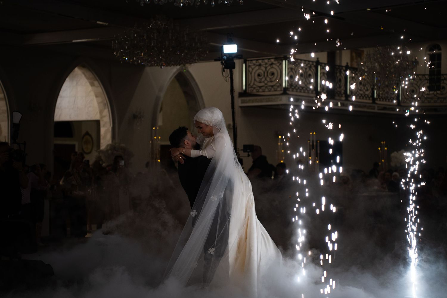 Wedding couple dancing surrounded by sparklers and fog effects.