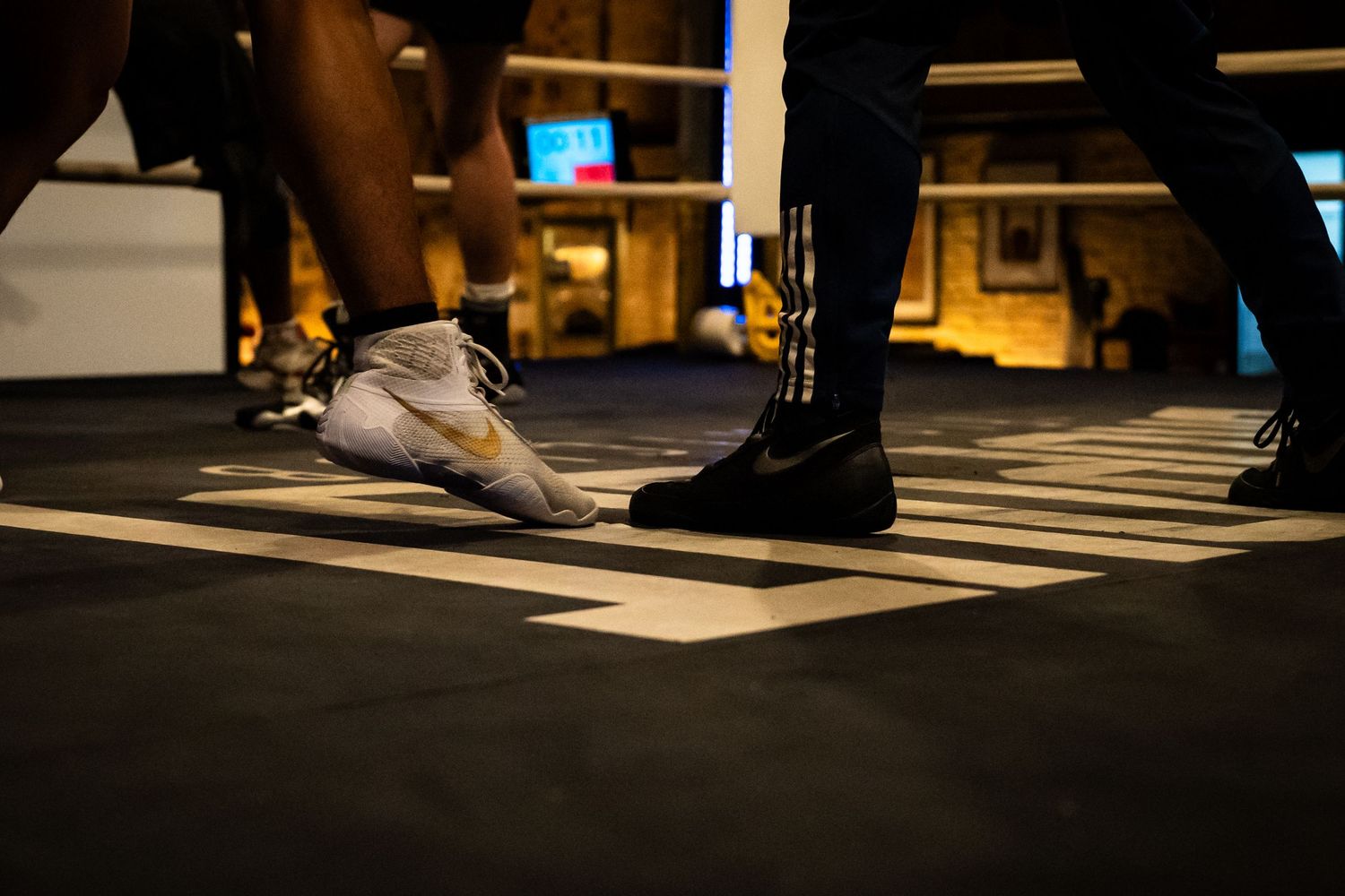 Artistic low-angle shot of dancers' feet in motion on a dark stage.