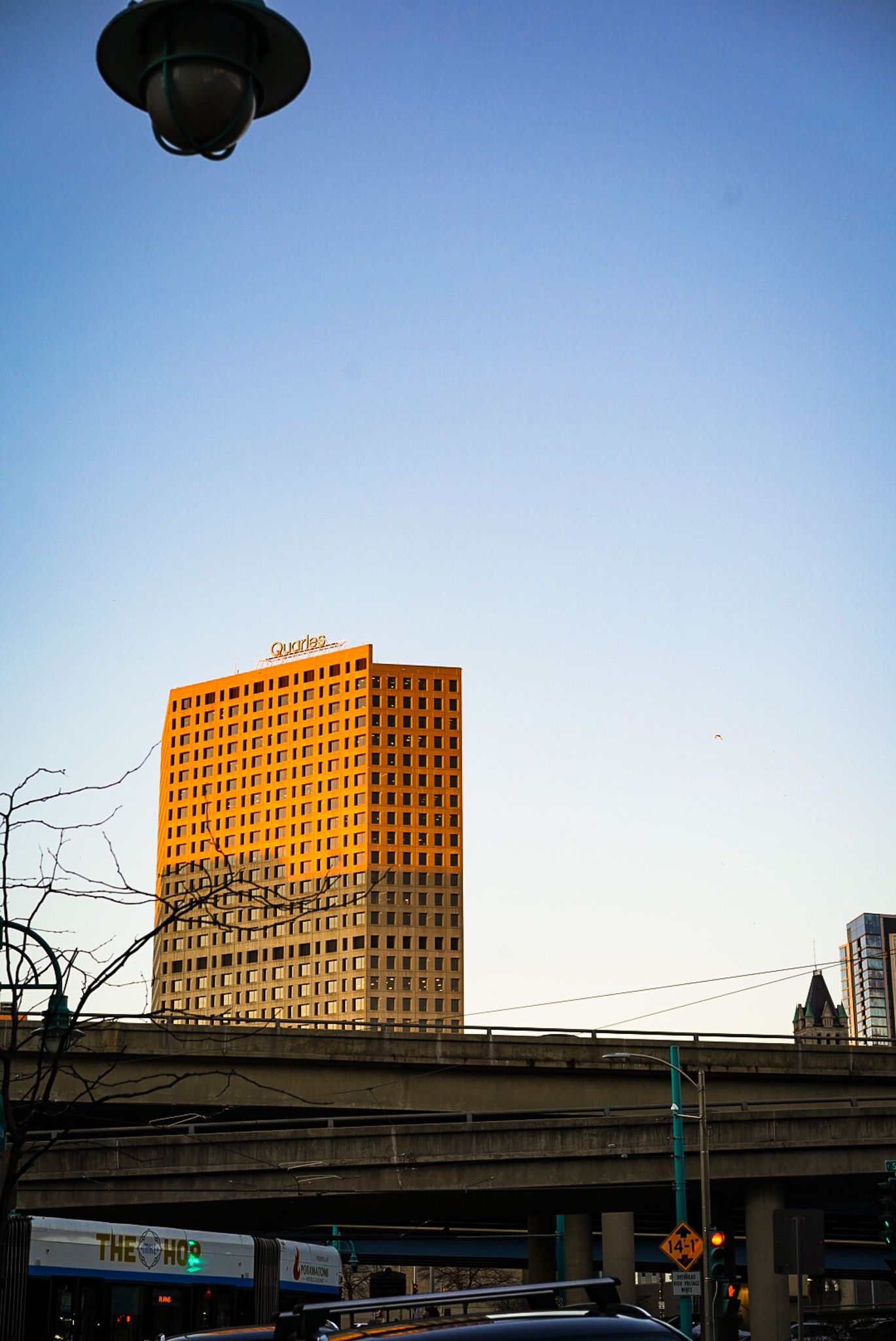 Large orange office building glowing in late afternoon sunlight against blue sky.