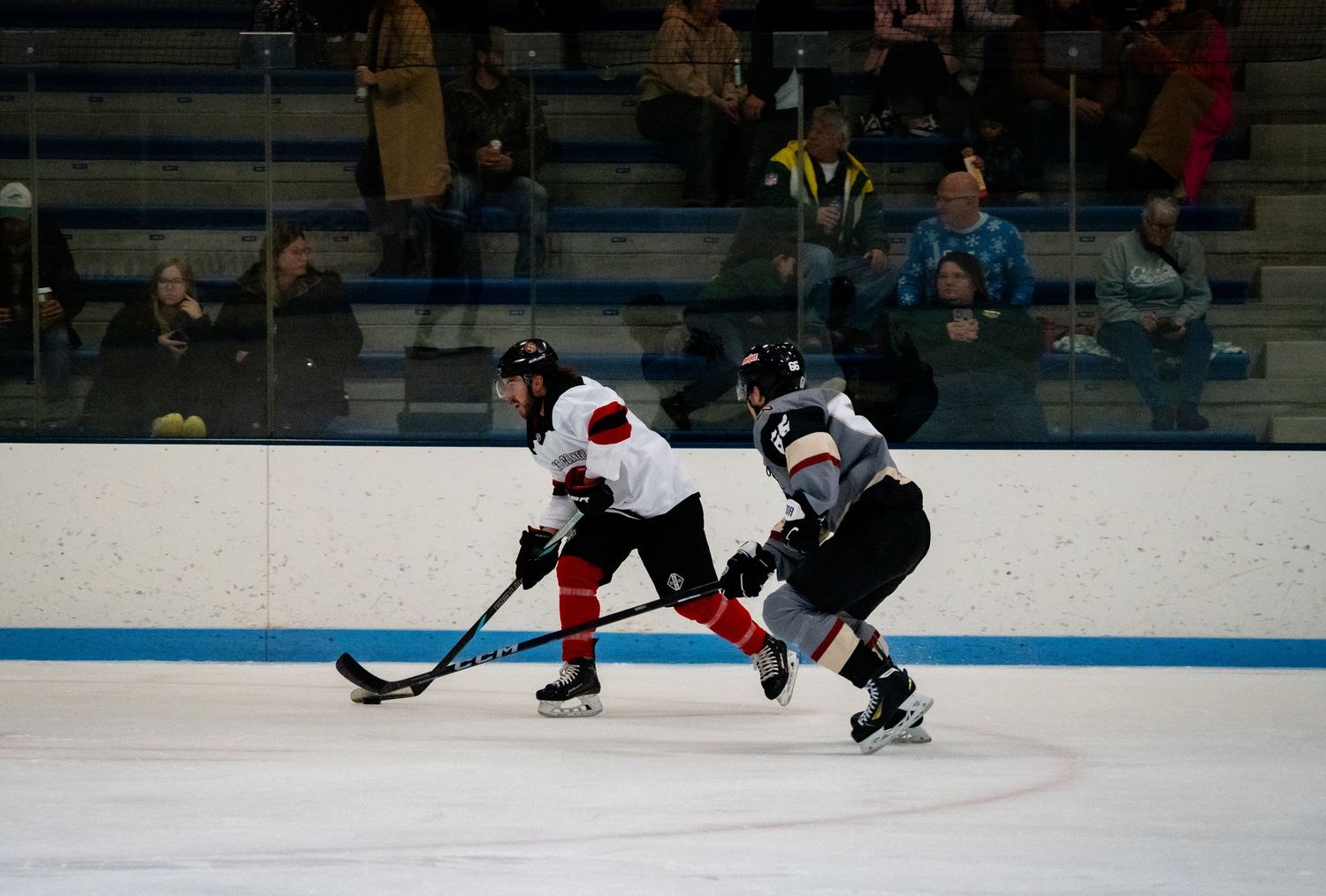 Two hockey players battle for puck control during intense game action.