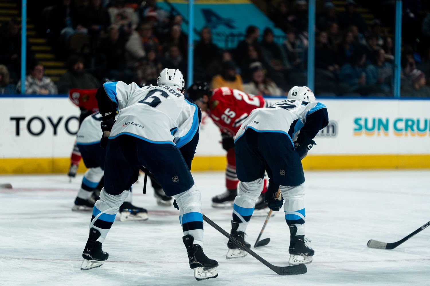 Hockey players compete for the puck during a fast-paced game.