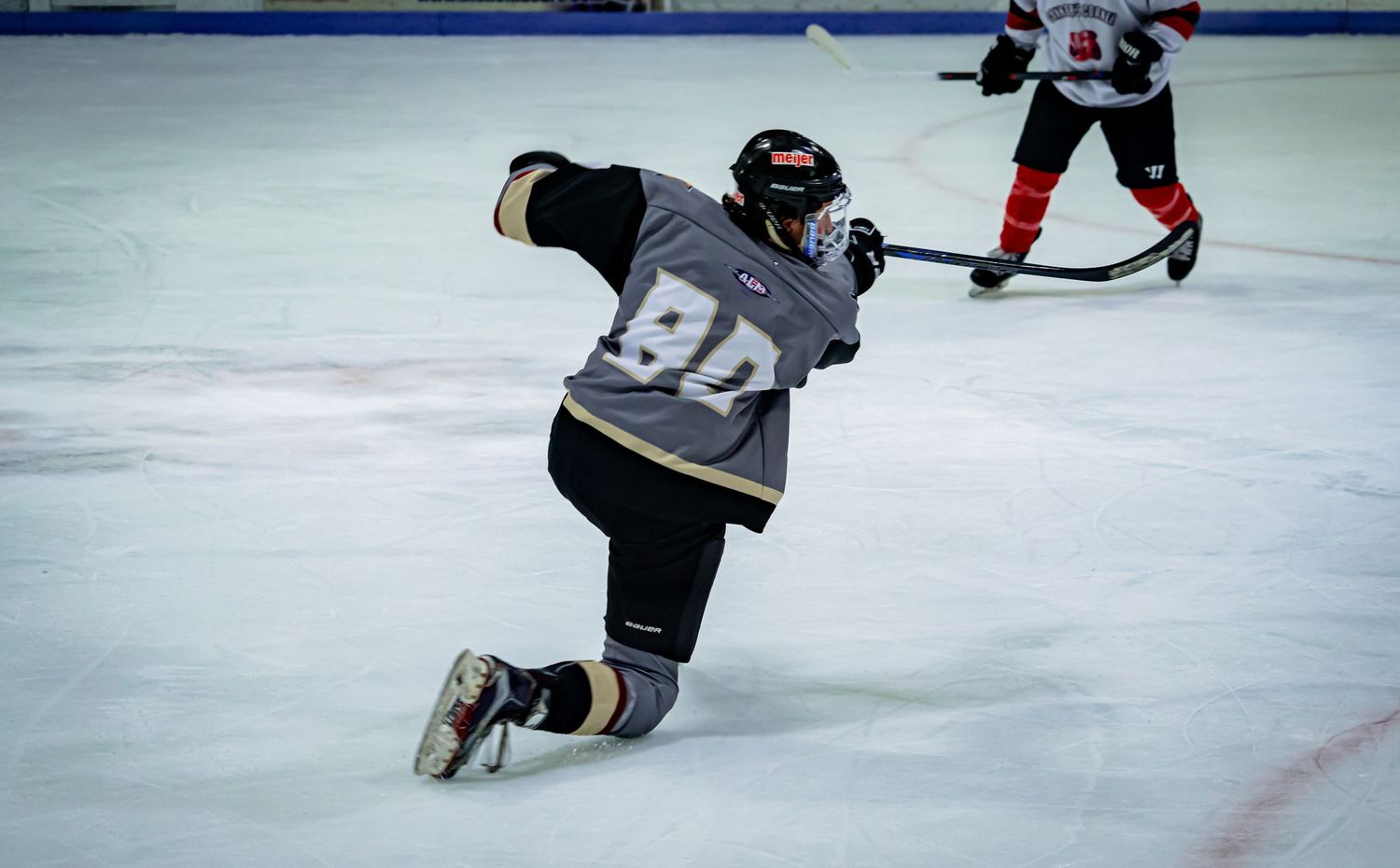 Players skate on ice during competitive hockey game action.