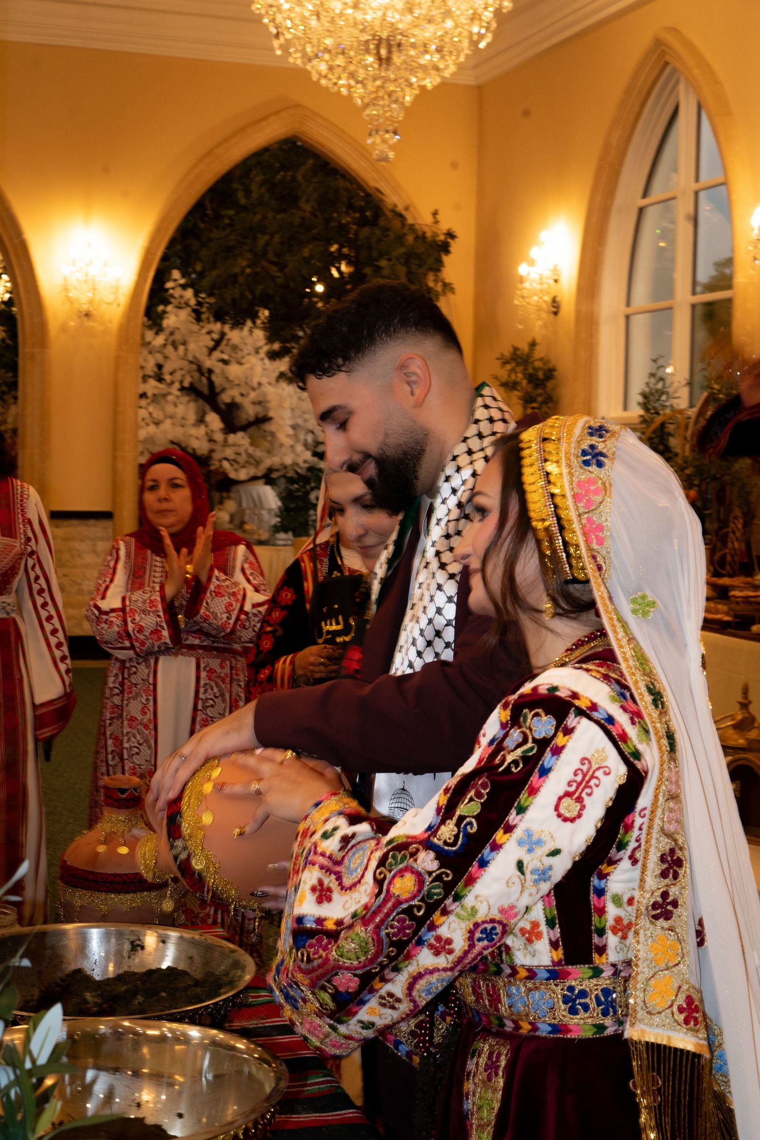 Traditional wedding celebration in an elegant ballroom with crystal chandeliers and ornate decor.