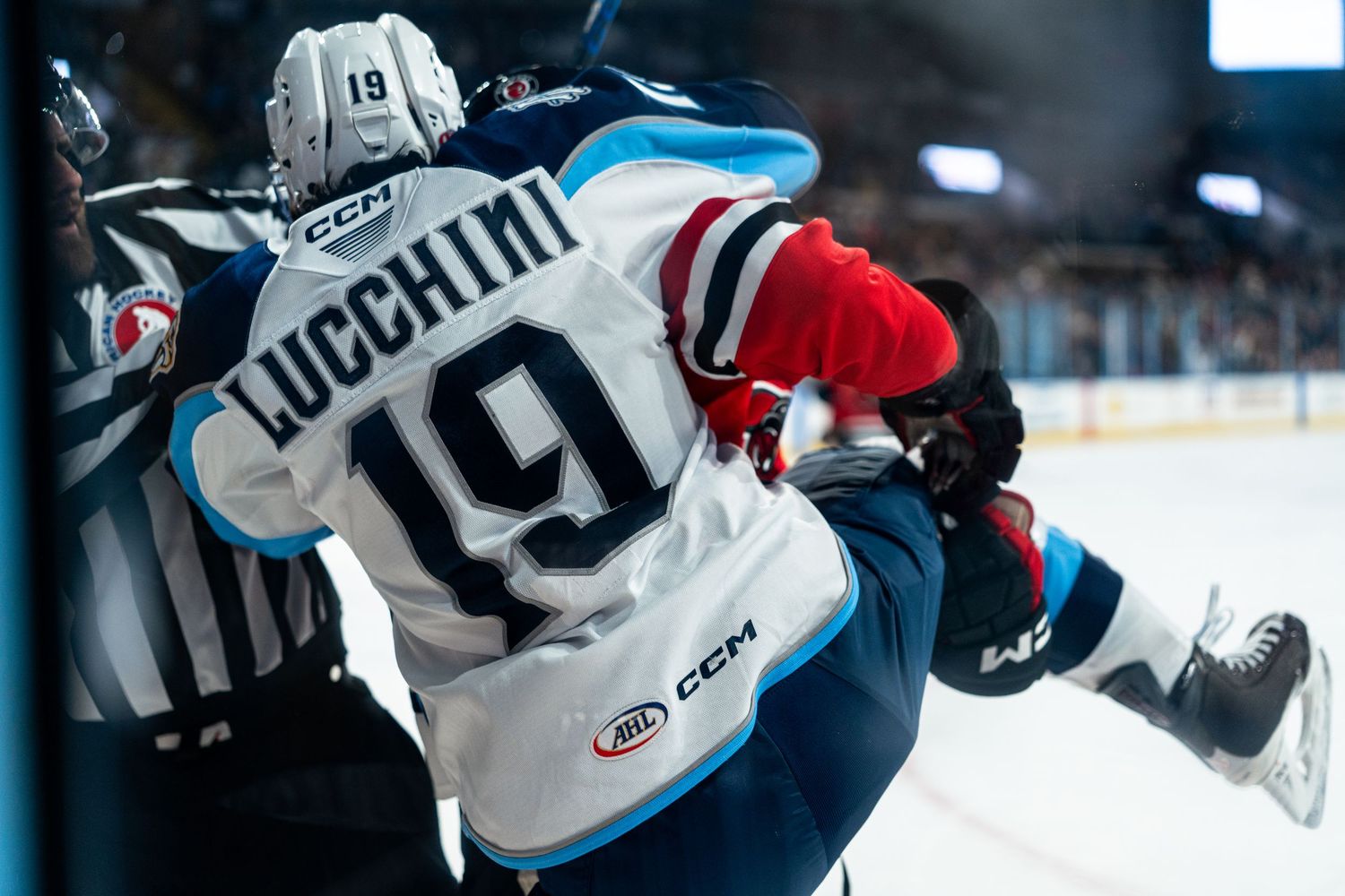 Hockey players from opposing teams battle for position during an intense game moment.
