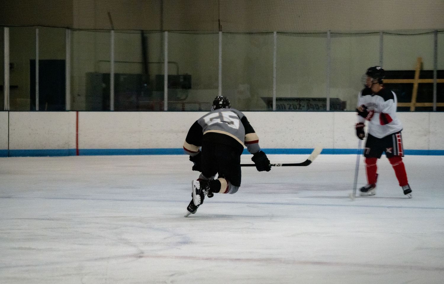 Hockey players skating on ice rink during competitive match.