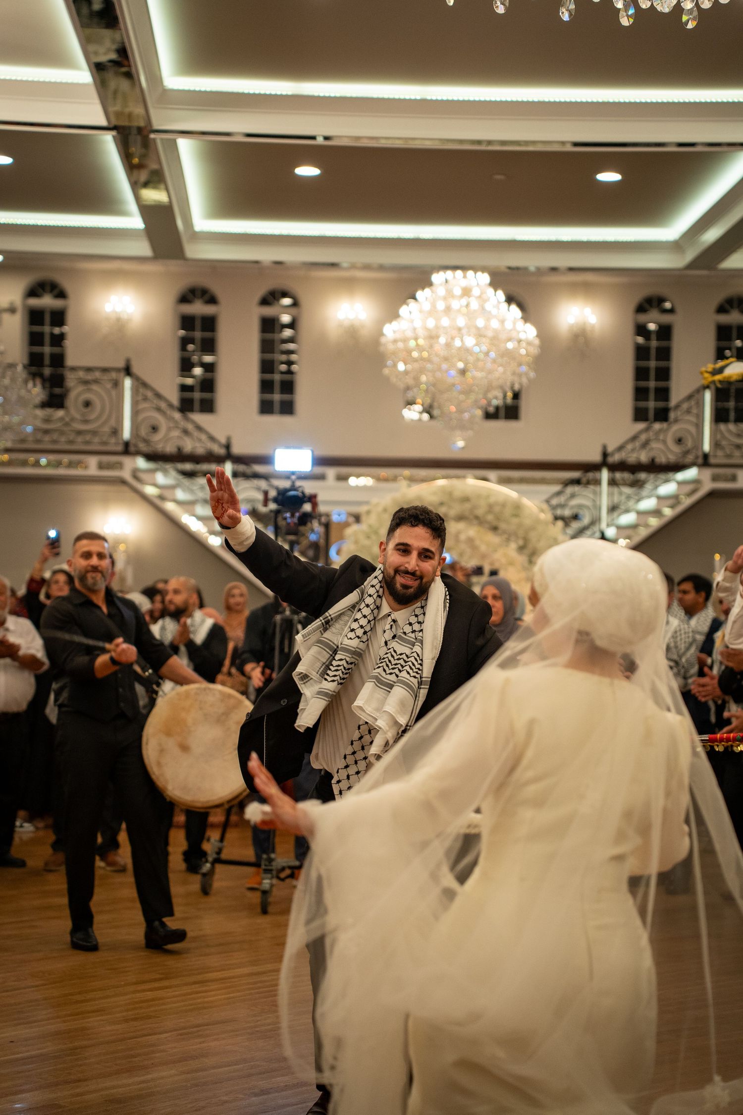 A couple dancing together during a wedding celebration in an elegant ballroom setting.
