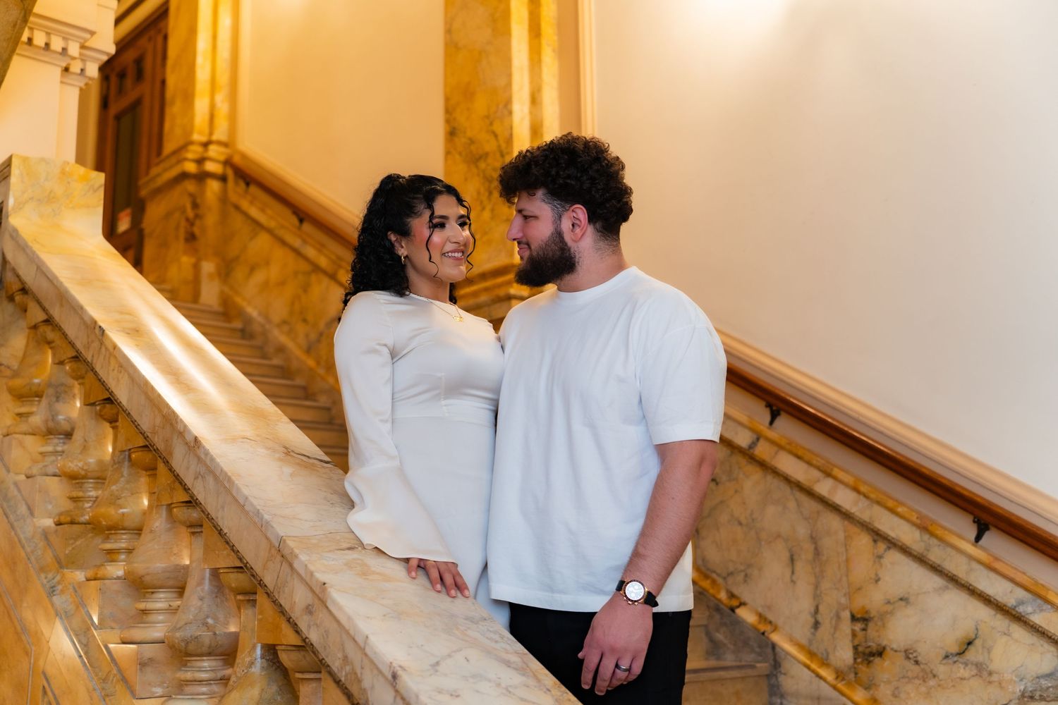 Romantic moment captured on an elegant marble staircase.