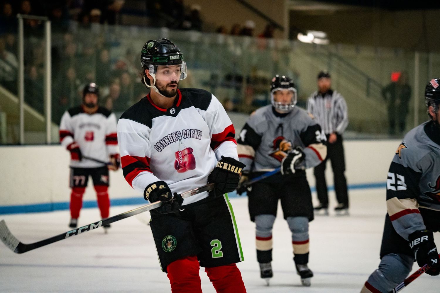 Hockey player in white and red jersey shows intensity during competitive match.