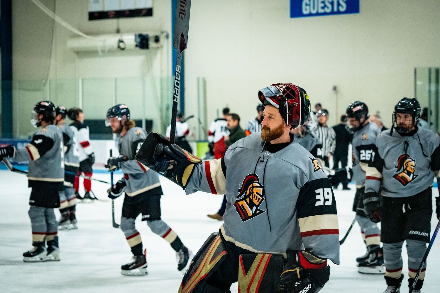 Wide view of hockey players on ice during practice or game at indoor arena.