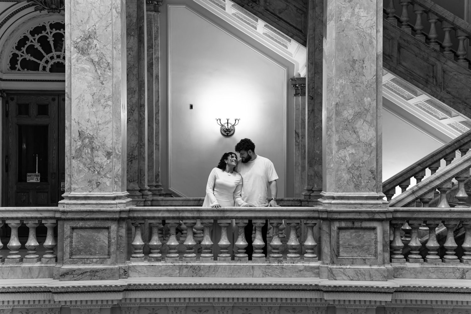 Classic marble staircase with dramatic lighting and architectural columns.
