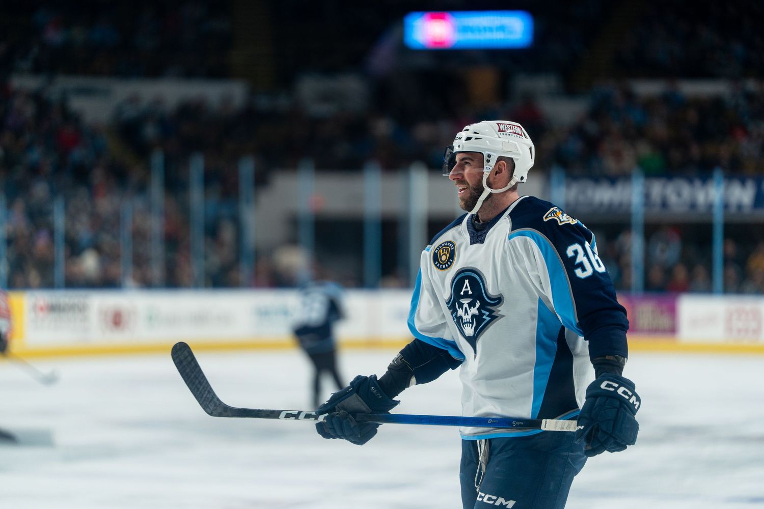 Hockey players in blue and white uniforms battle for position during gameplay.