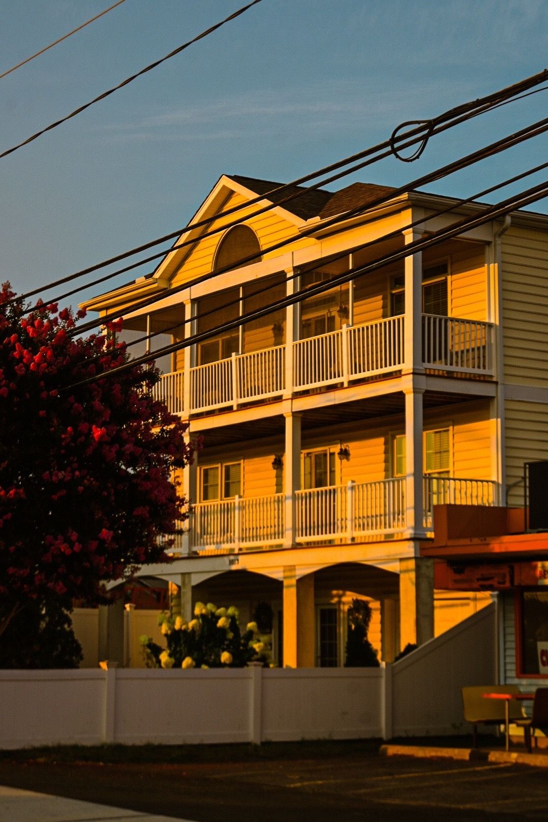 Yellow apartment buildings with white balconies glowing in golden sunset light.