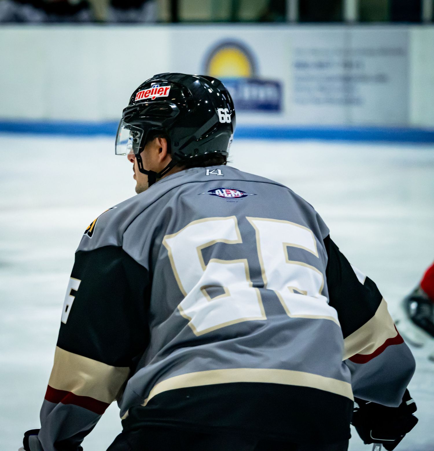 Hockey player wearing jersey number 55 skates during competitive match.
