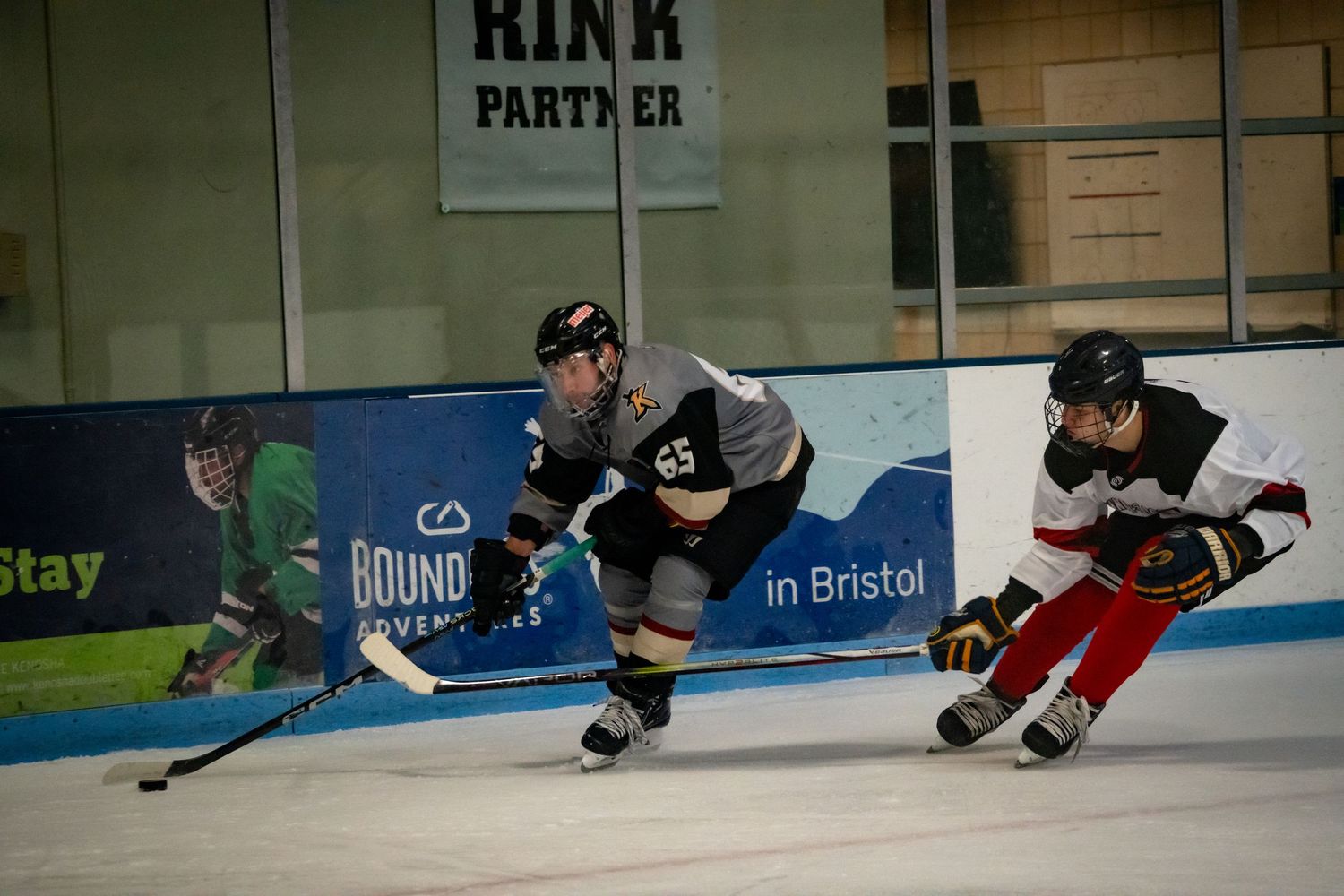 Ice hockey players practicing skating drills on a rink during training session.