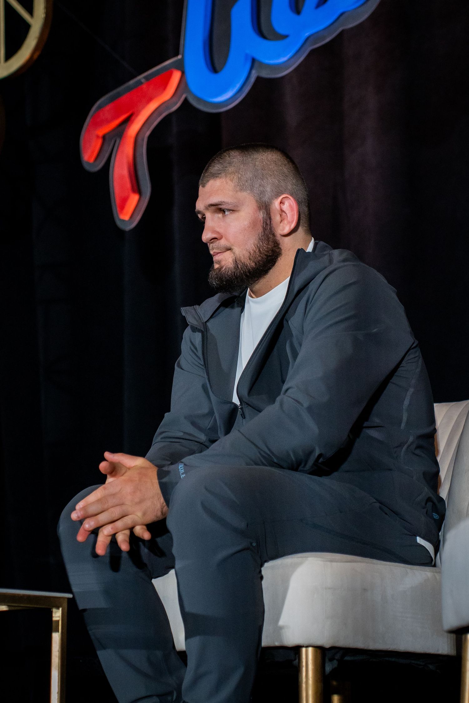 A sequence of photos showing someone in a dark suit seated during what appears to be a business presentation.