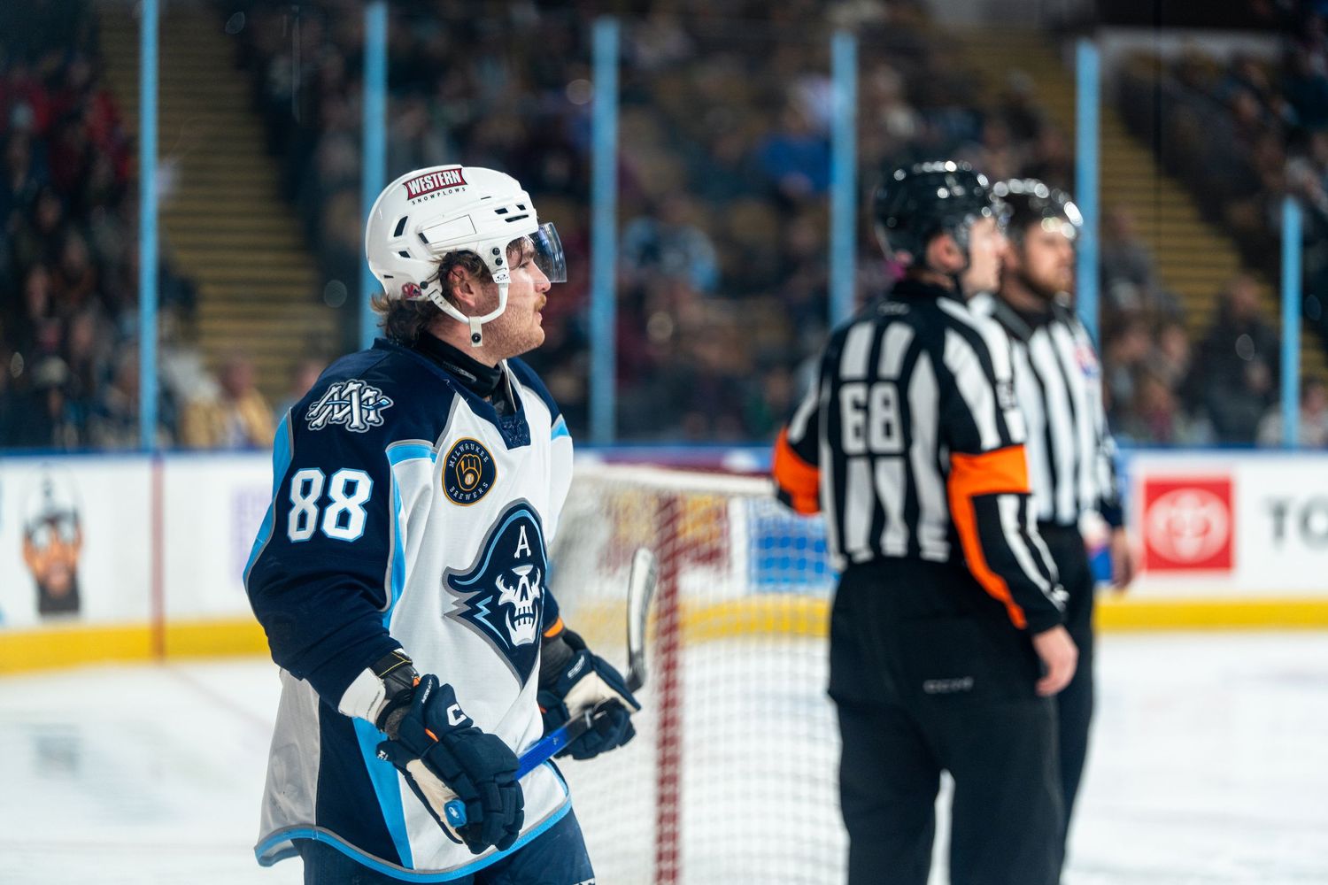 Players and officials gather on the ice during a professional hockey game.
