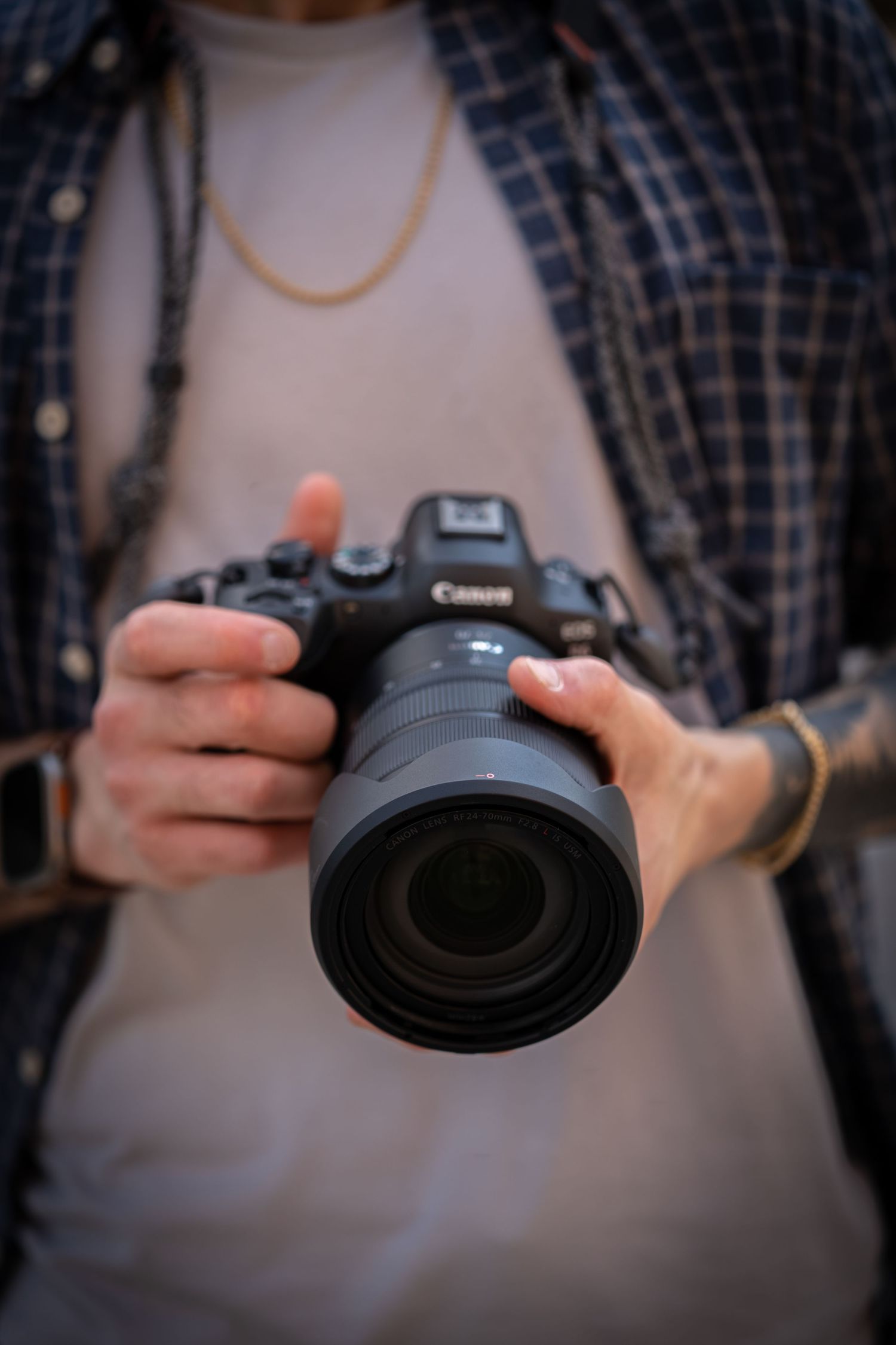 Detailed view of hands adjusting settings on a Canon DSLR camera.